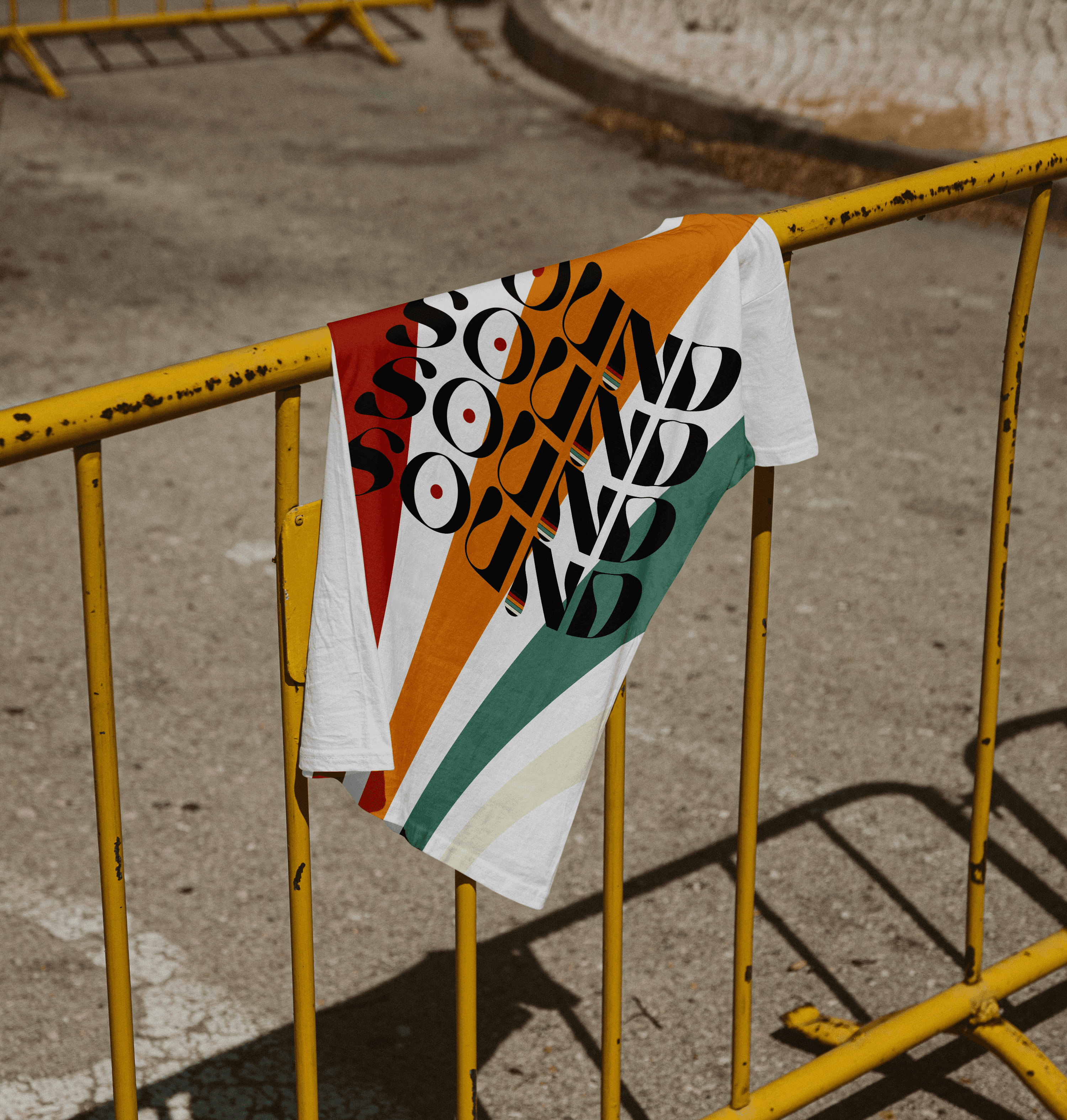 A yellow barrier with a colorful garment draped over it, placed on a concrete surface.