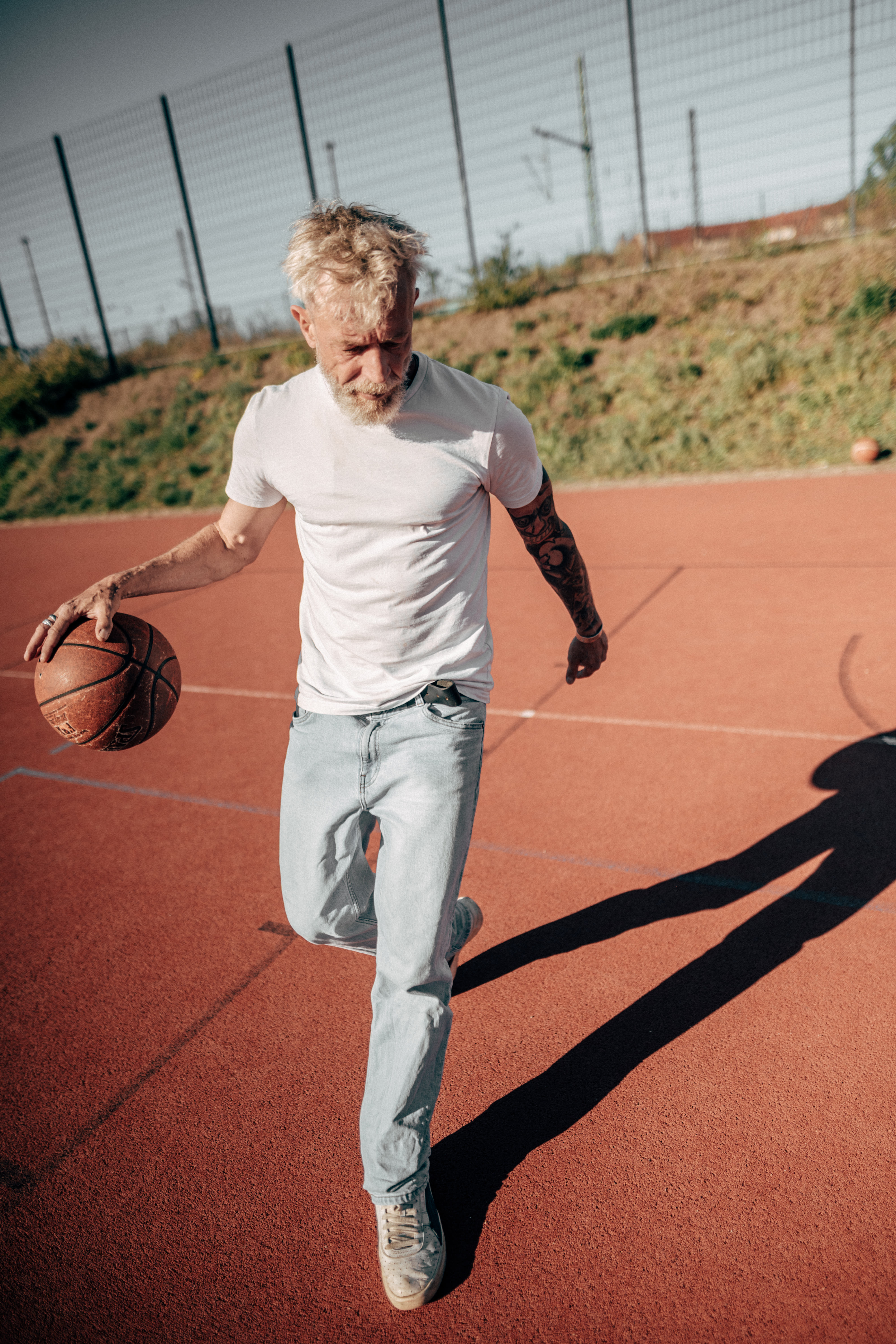 sthende sportliche szene mit basketball sport und fitness model best ager