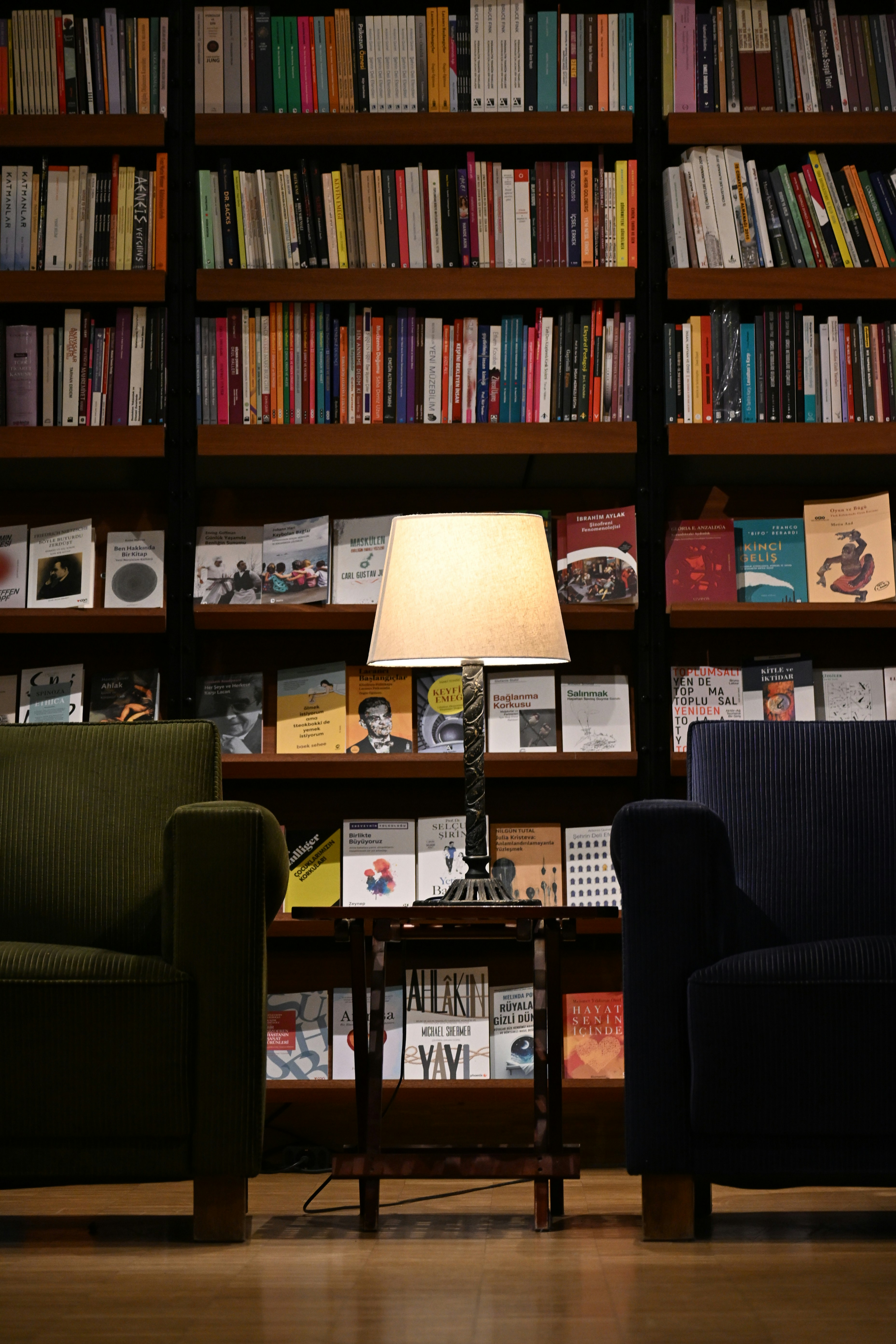 Two armchairs flank a table with a lamp.