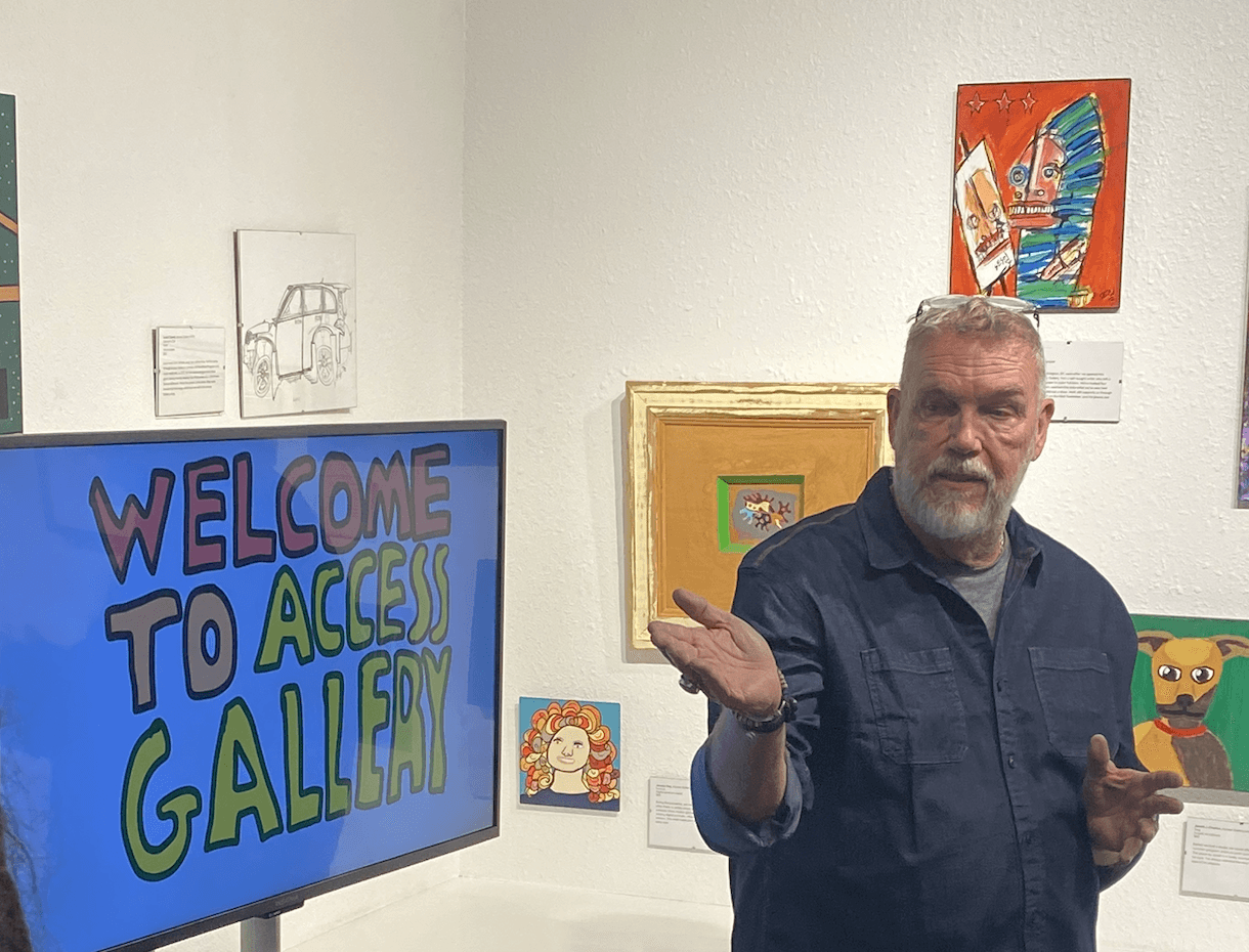 Access Gallery Executive Director Damon McLeese speaks during the gallery’s 20th anniversary celebration, surrounded by artwork featured in 20 Years in 20 Pieces of Artwork.