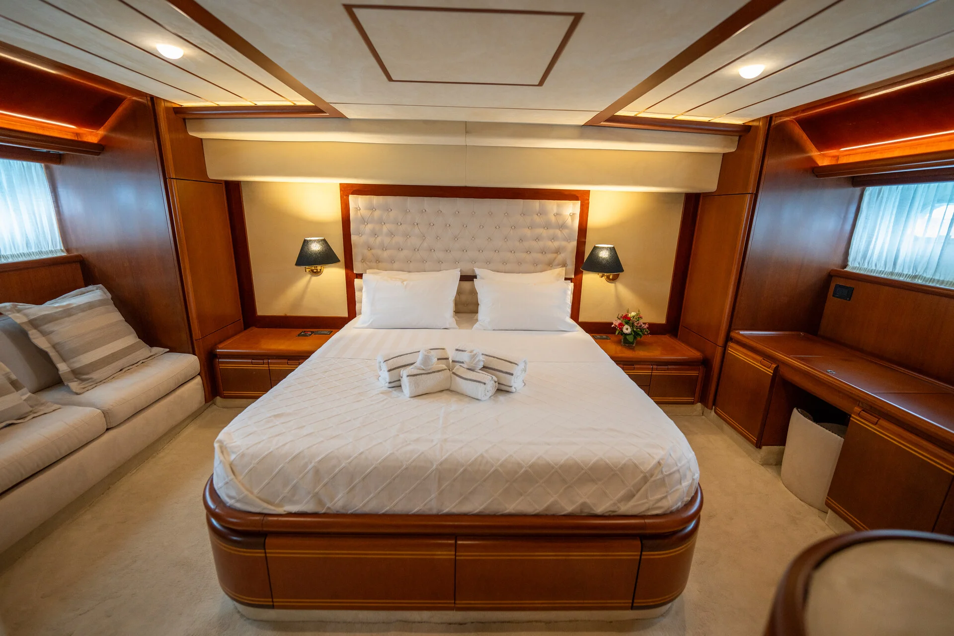 White Rock 36 speedboat with captain at helm cruising calm blue waters near Paros coastline with hills in background.