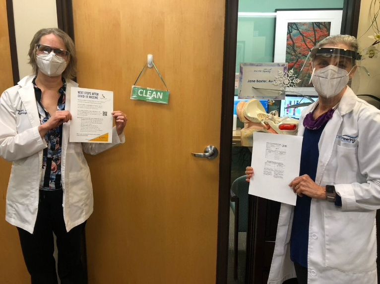 Jane and Deborah with vaccine notice