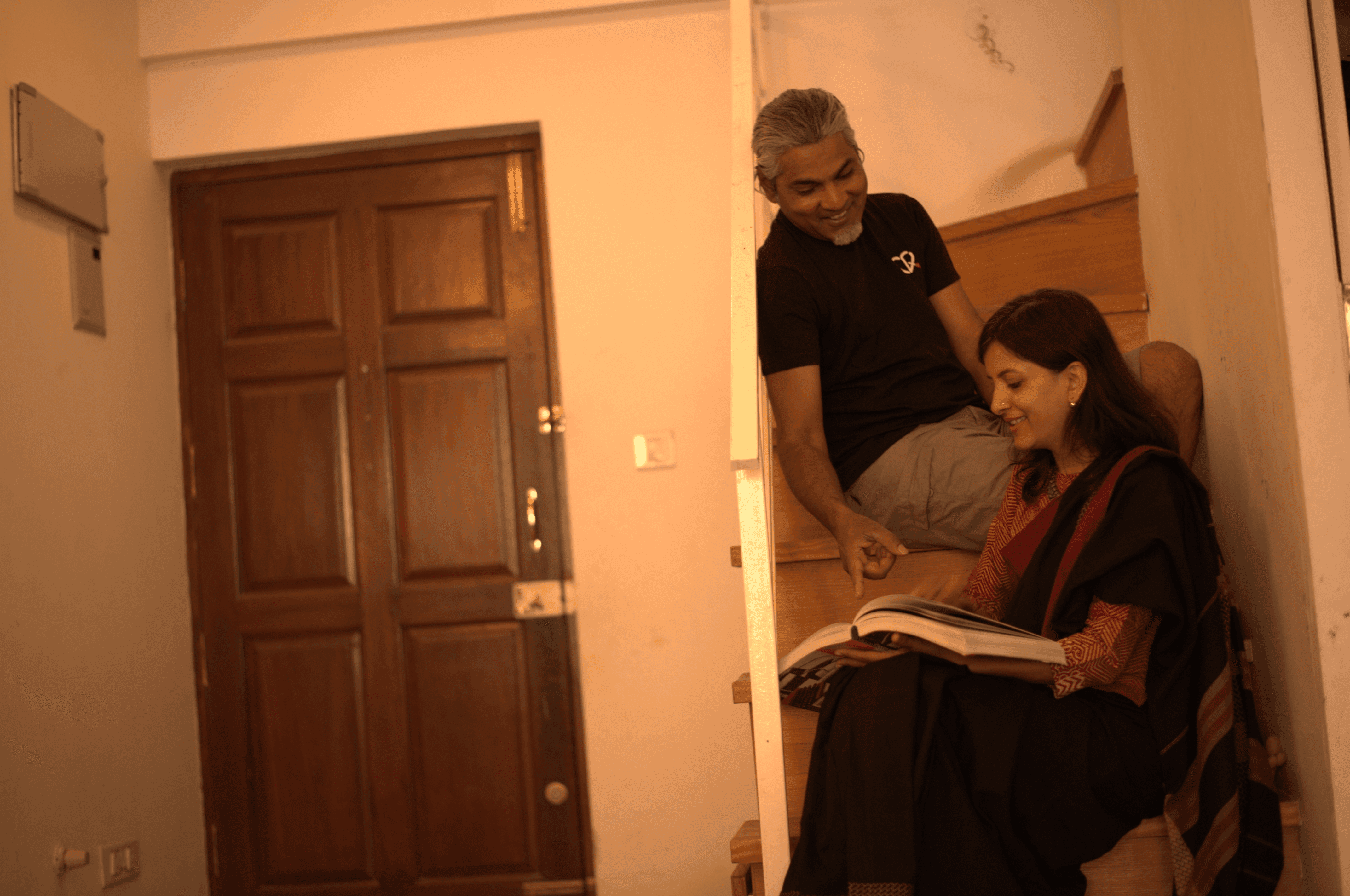 A couple stands outdoors at sunset.
