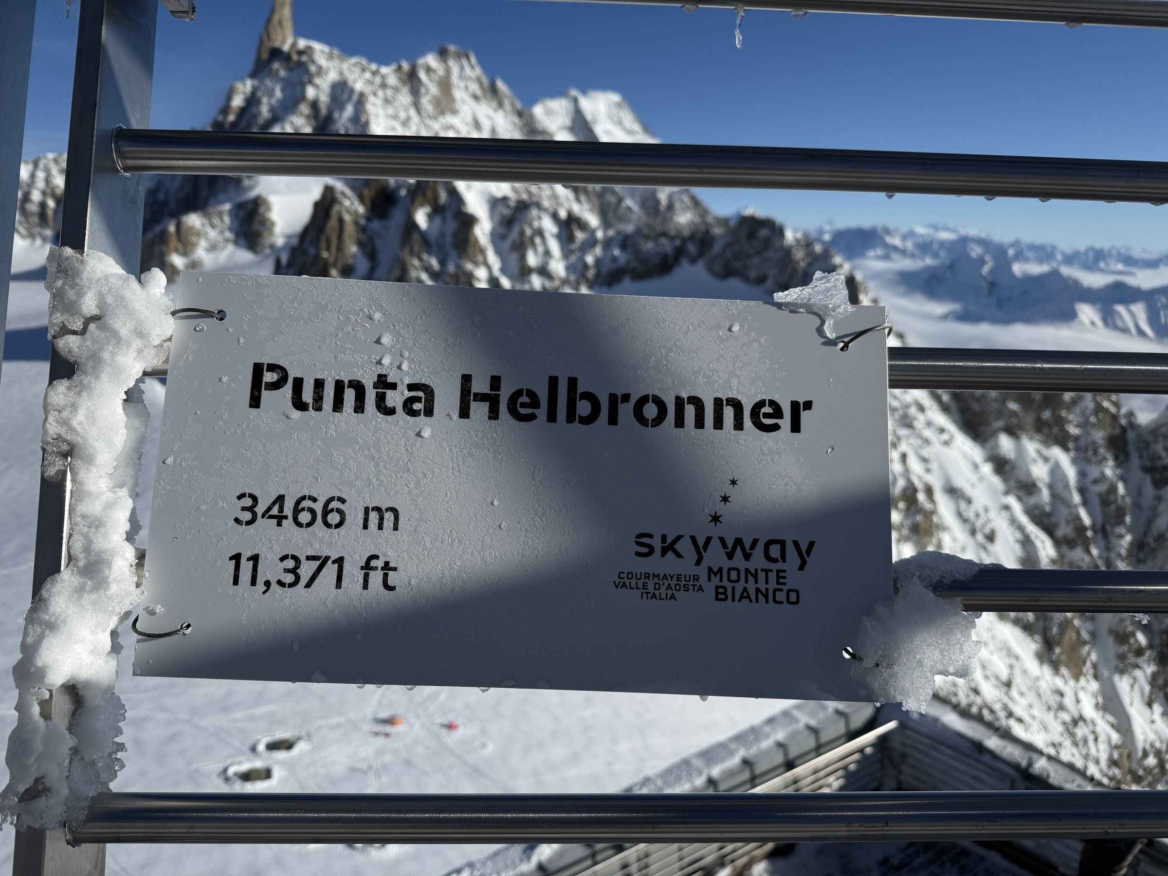 Punta Helbronner 3466 m sign on an icy railing at the Skyway Monte Bianco terrace, Courmayeur