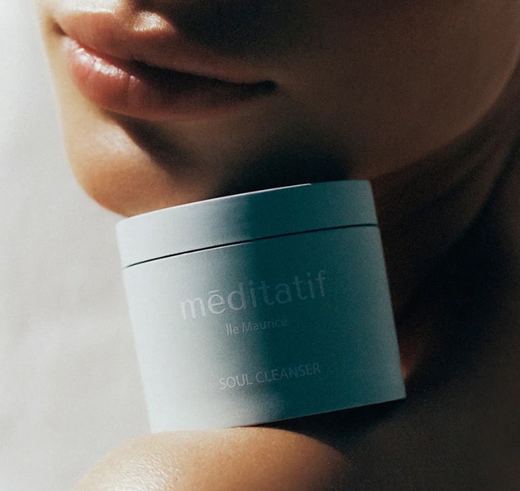 A lifestyle image featuring Méditatif Soul Cleanser Balm in a 50ml blue VIVOMER tub. The vibrant colour match proves that microplastic-free packaging can maintain strong brand identity on the retail shelf.