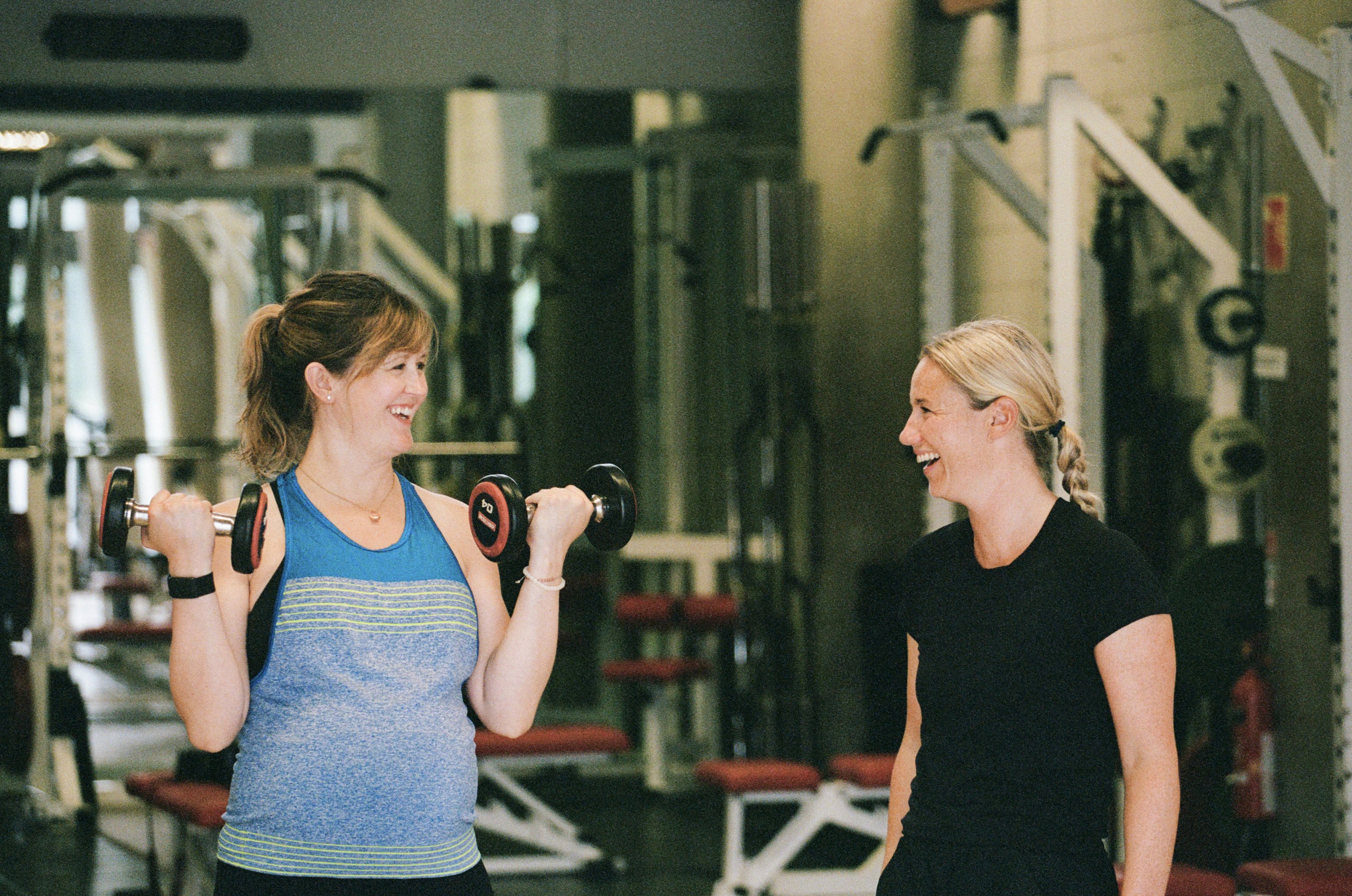 Personal trainer helping antenatal client with stretches