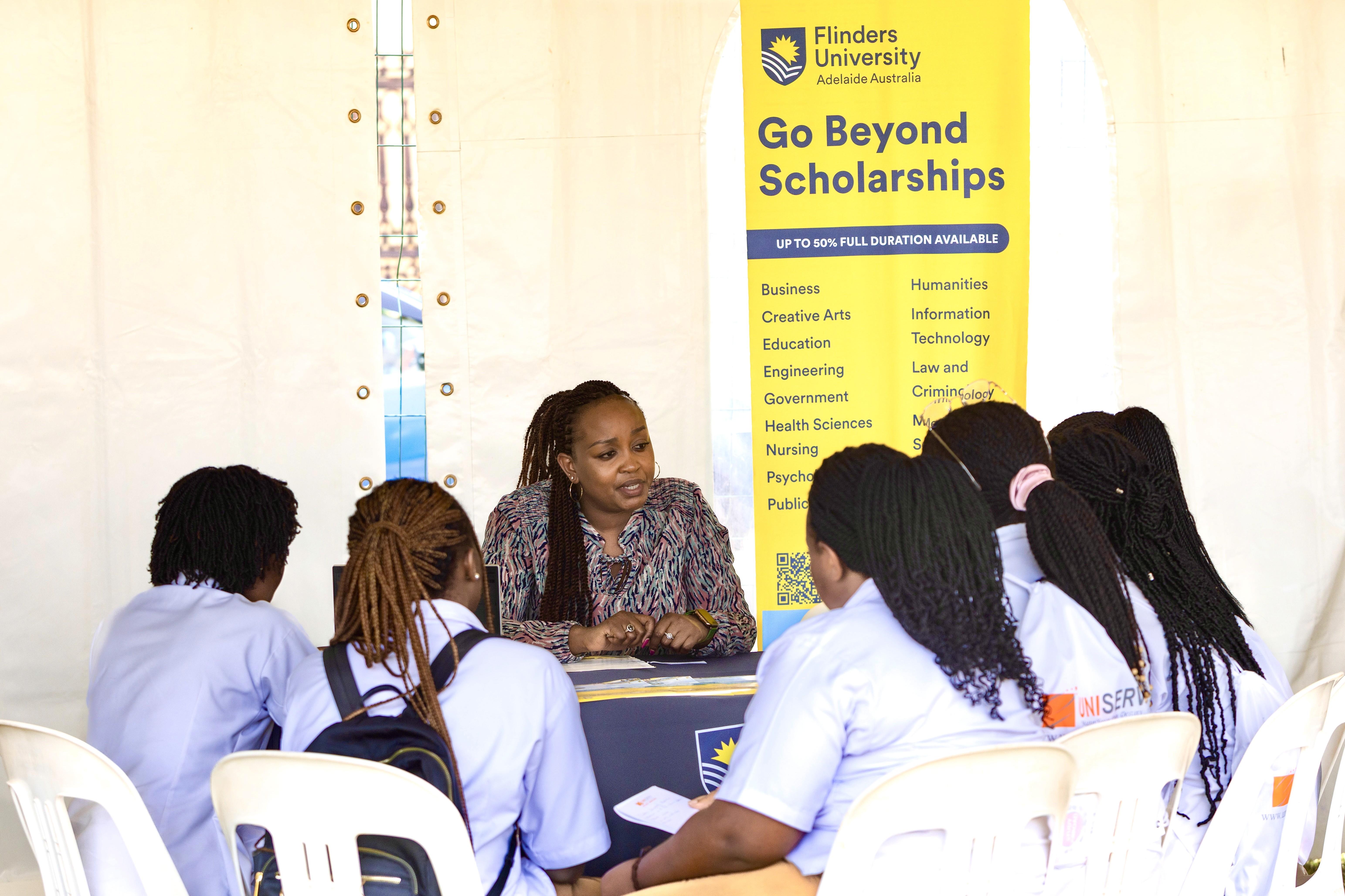 Children are sitting on the grass, reading a book together