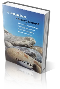 a black and white cat laying on top of a white wall