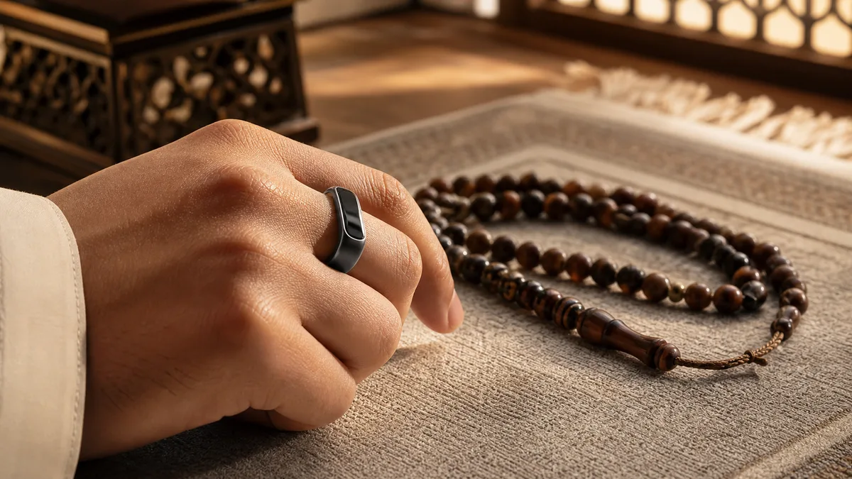 Smart dhikr ring beside misbaha beads on a prayer mat in warm light