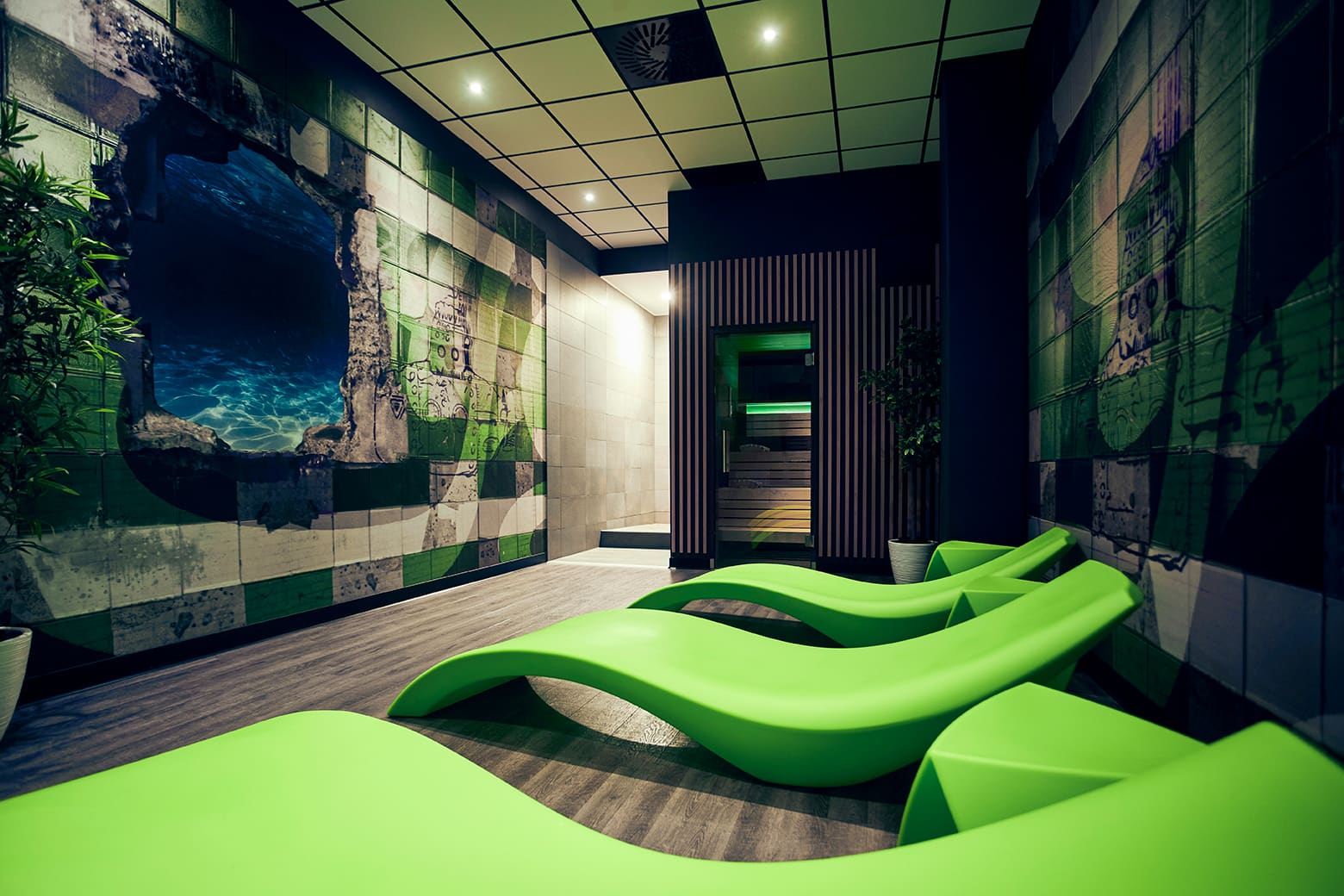 Der Sauna-Bereich, mit grünen Liegen im Vordergrund im XTRAFIT-Studio Essen-Vogelheim