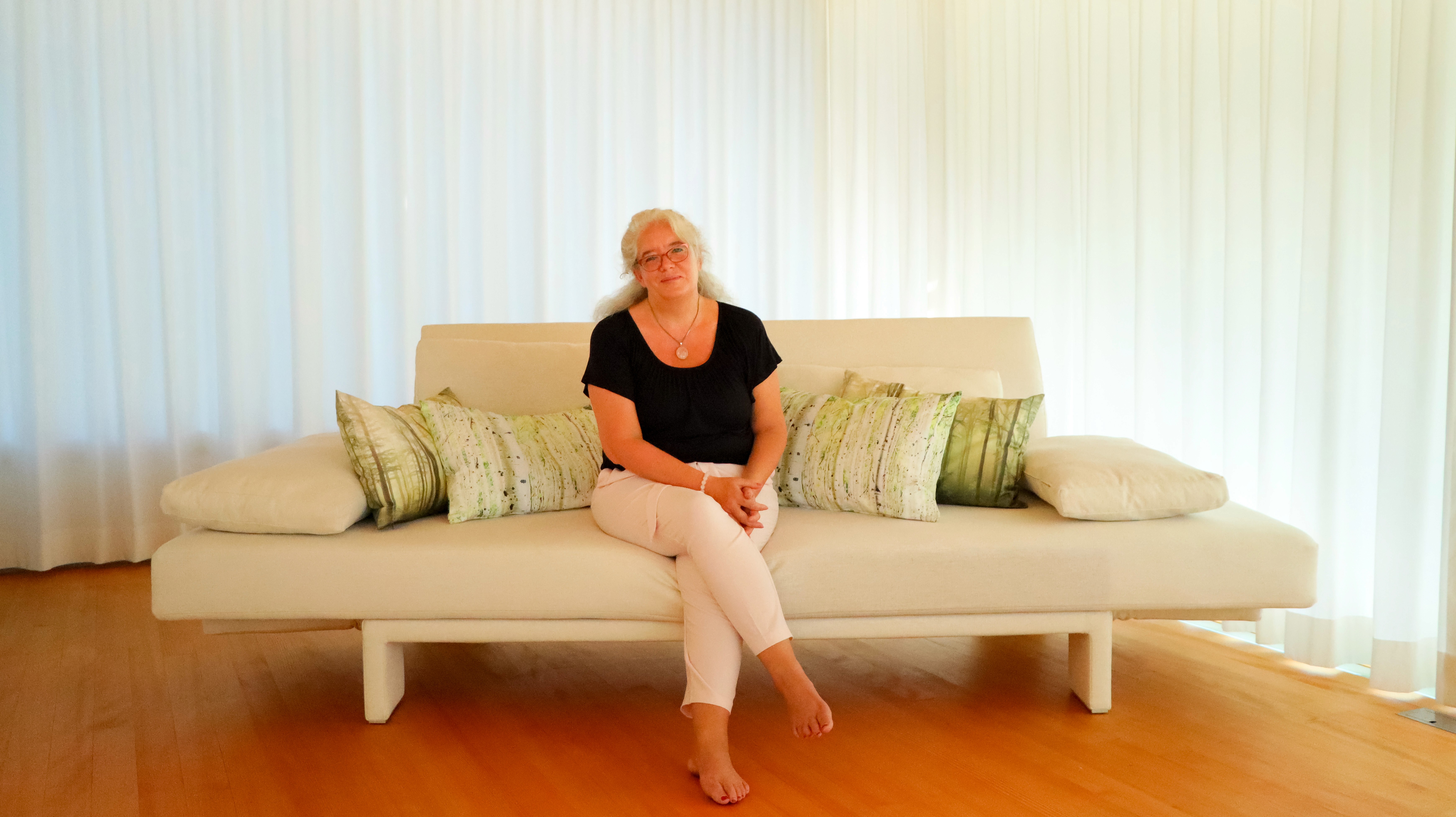Brigitte Maria Maier, Expertin für Seelenfeldprofiling, auf einer Couch.
