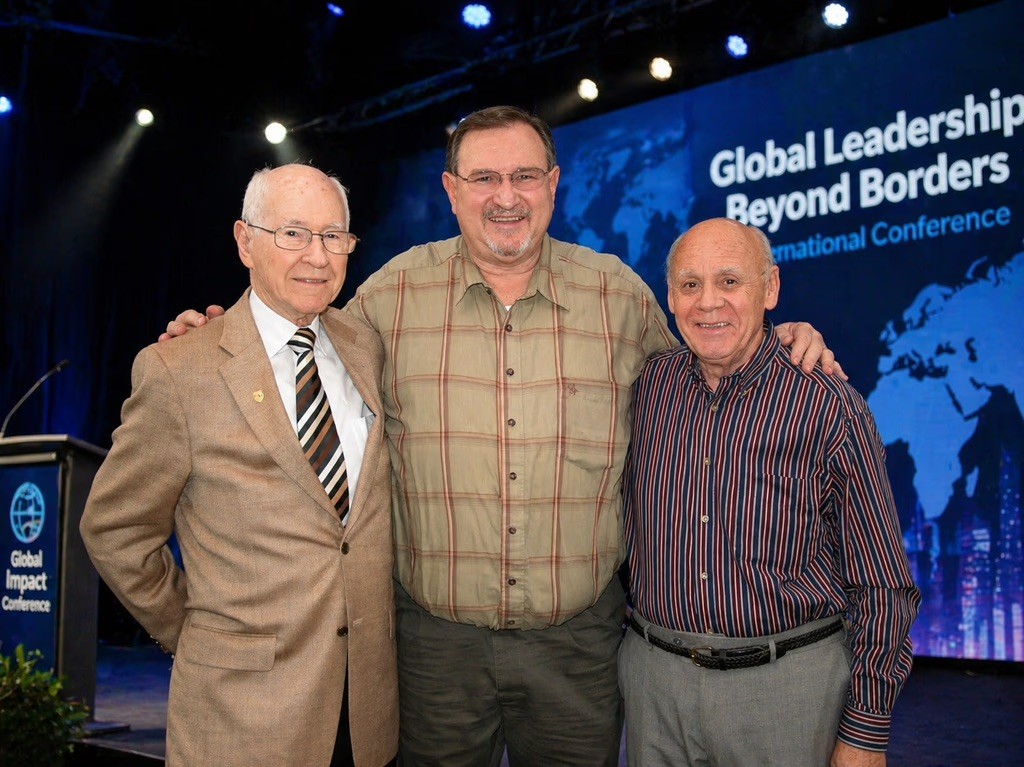 Pastors standing on a stage with colorful background.