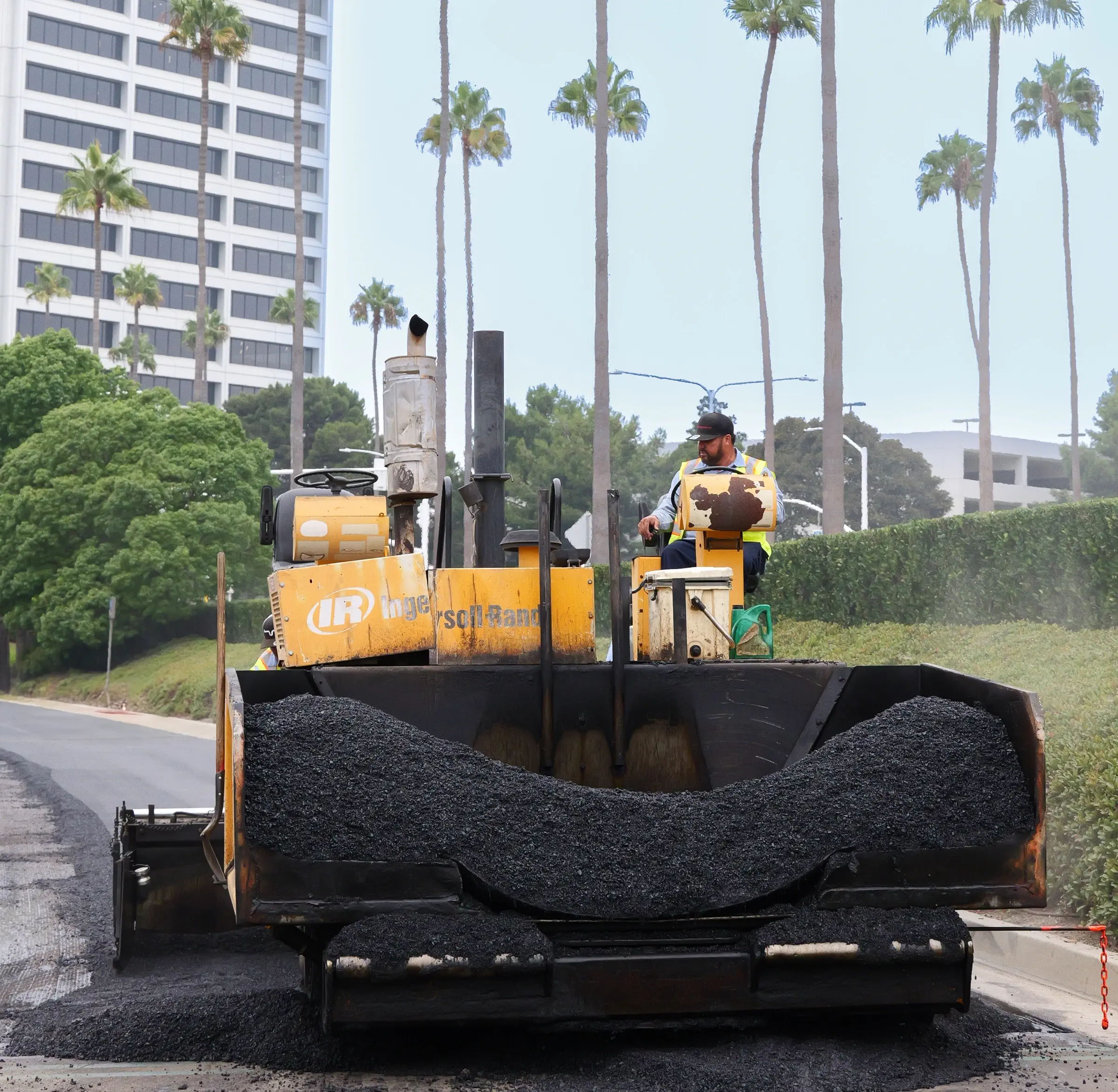 Paving machine on asphalt project with hot mix asphalt inside hopper