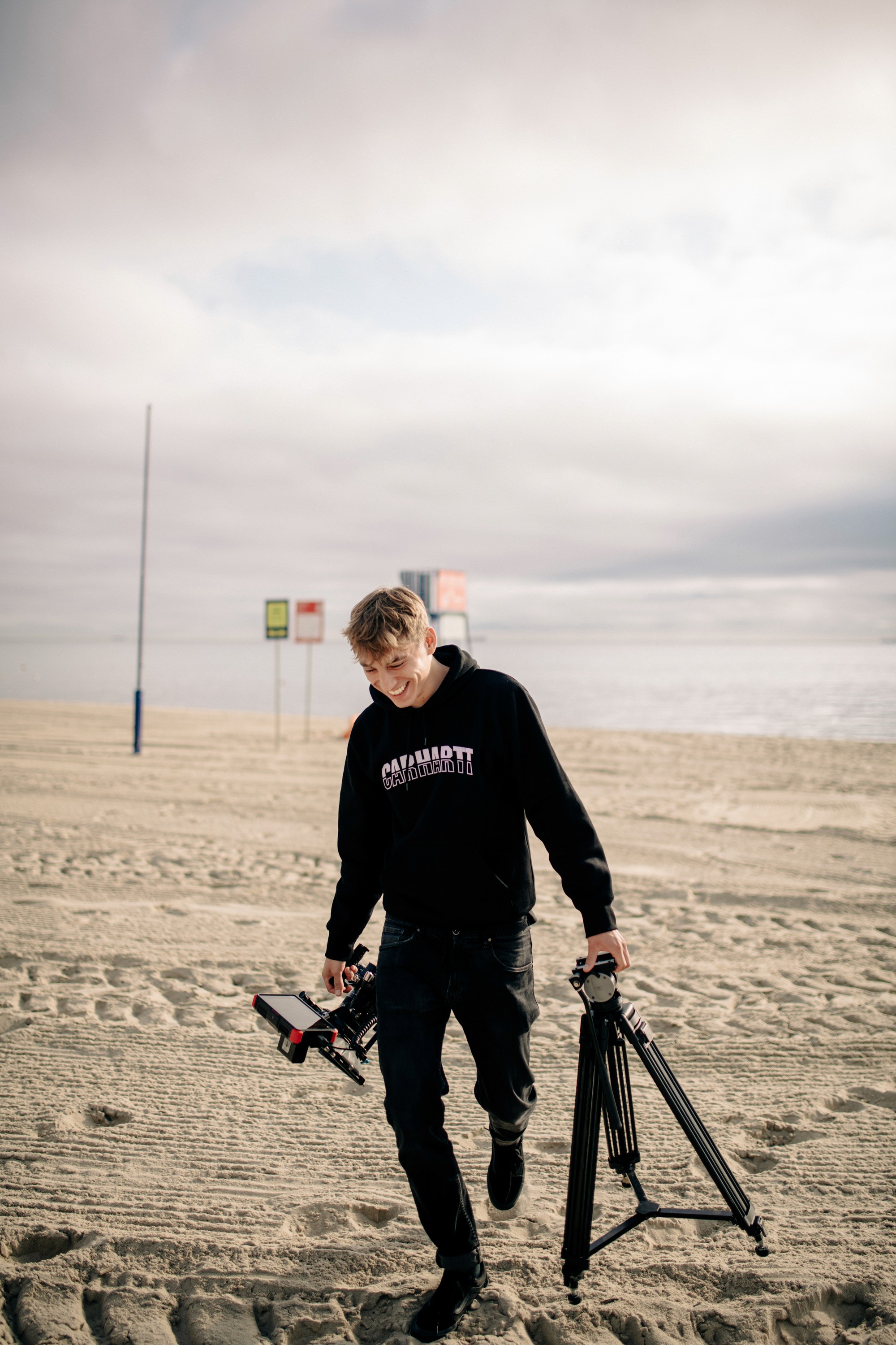 A thoughtful young person with dark hair gazes to the side, captured in soft black and white lighting.