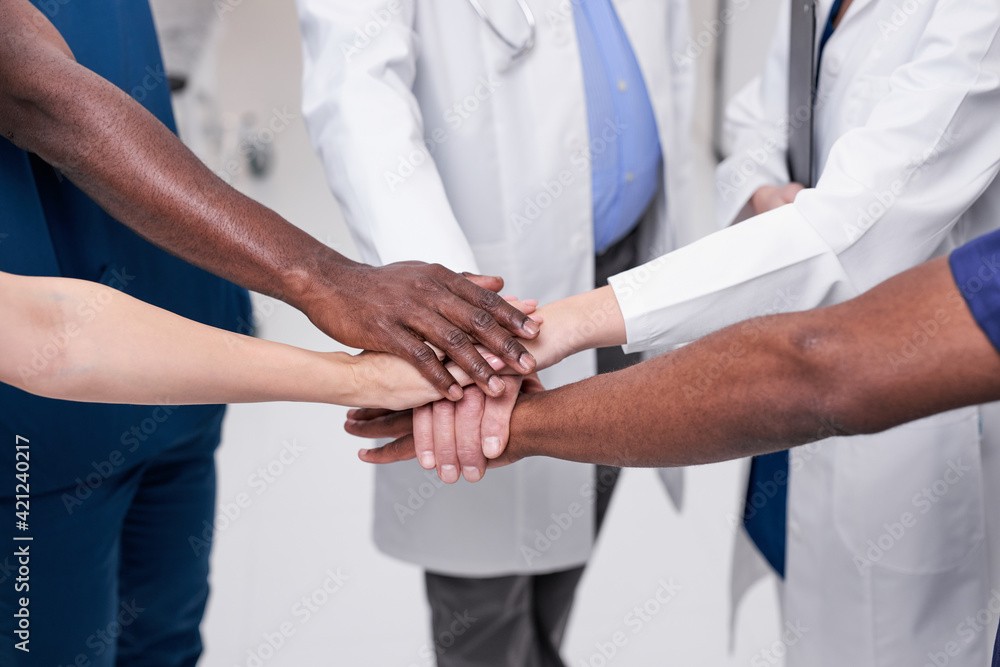 image of healthcare team putting their hands all in the center