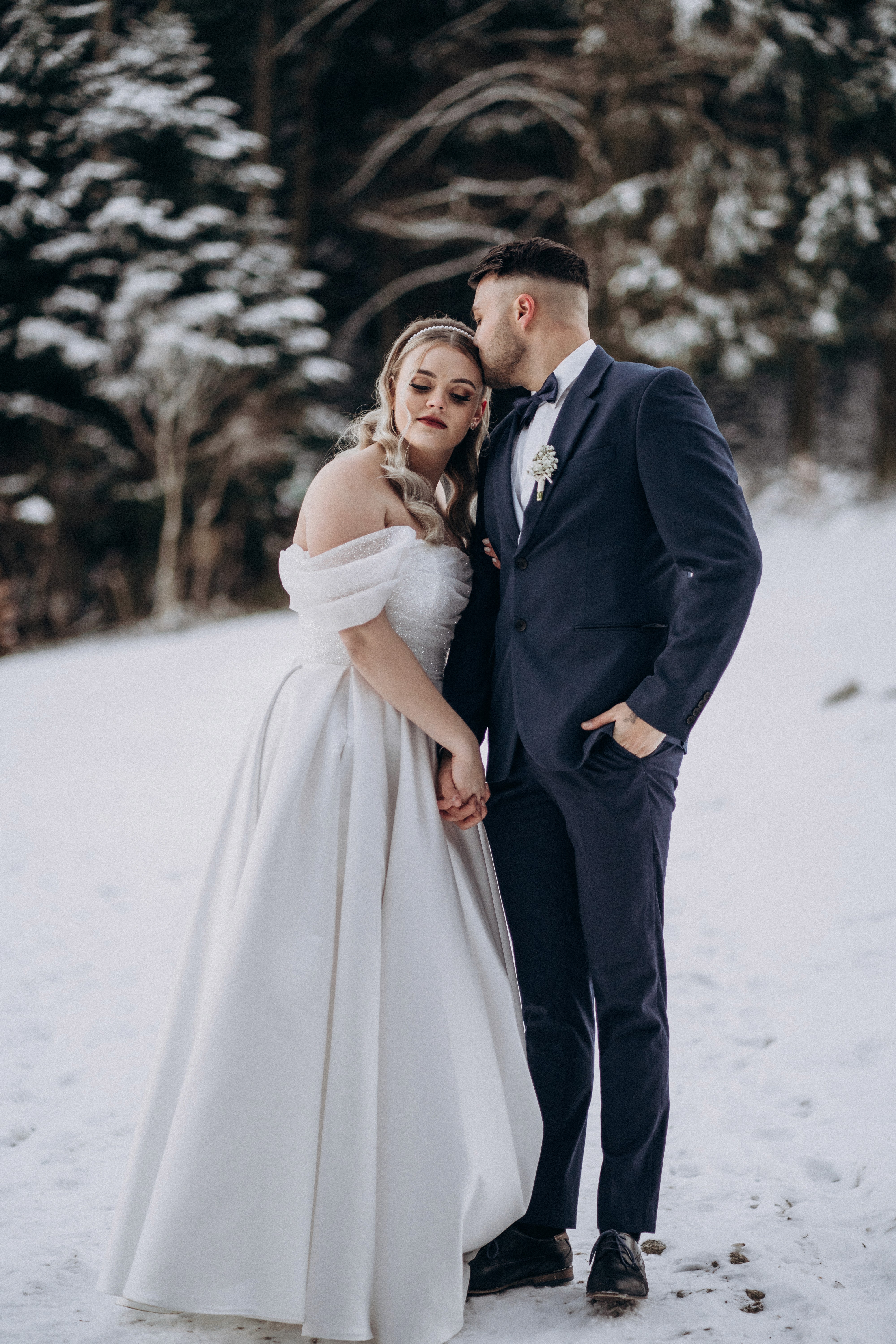 Emotionale Hochzeitsfotografie in Bogen, Bayern – Brautpaar bei einem intimen Moment im Schnee.