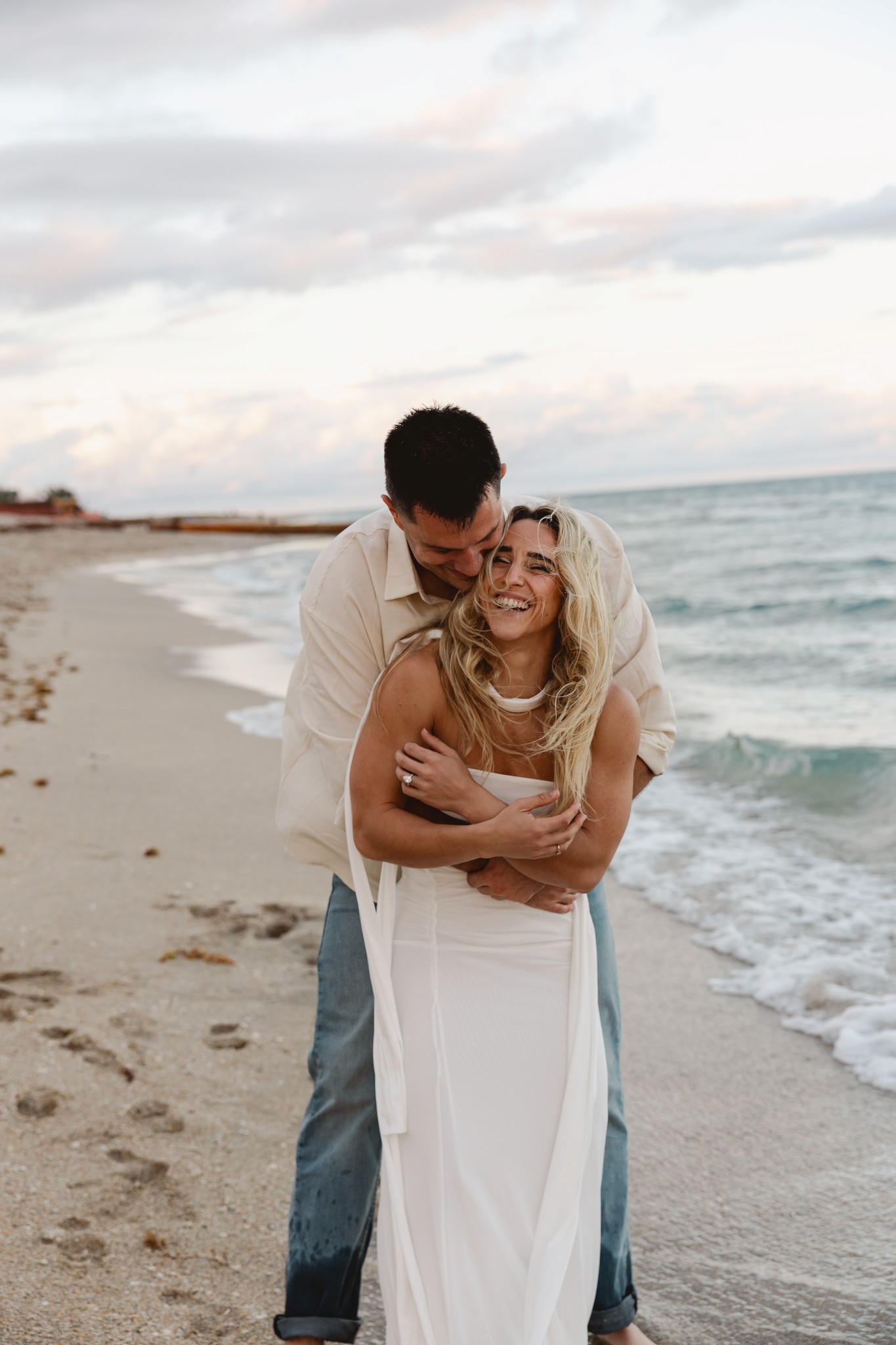 Wedding photographer in south florida captures couple embracing at golden hour on the beach.