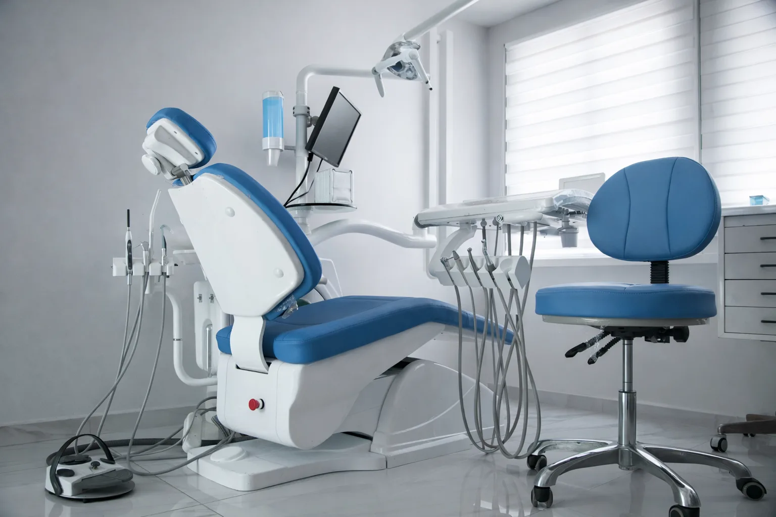 Modern dental clinic chair with equipment in a clean treatment room