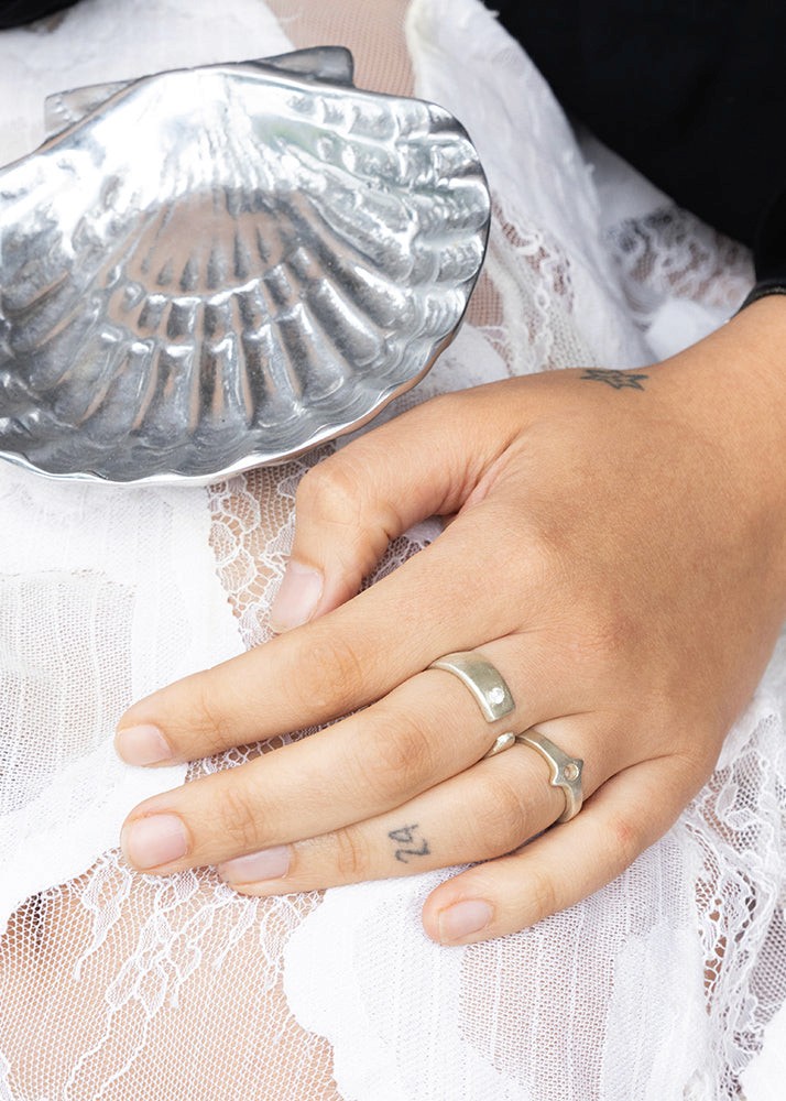 Silver ring on a hand with a white lace garment