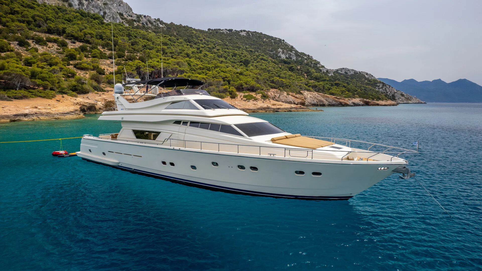 White Rock 36 speedboat with captain at helm cruising calm blue waters near Paros coastline with hills in background.