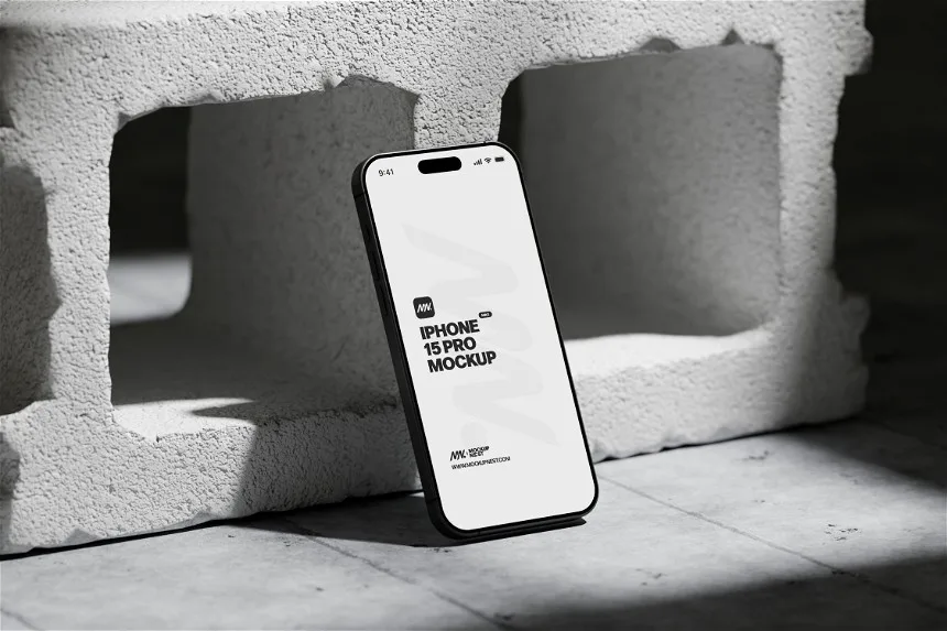 iPhone 15 Pro mockup standing upright against a textured concrete block. The industrial backdrop, paired with dramatic lighting, highlights the sleek and modern design of the device.