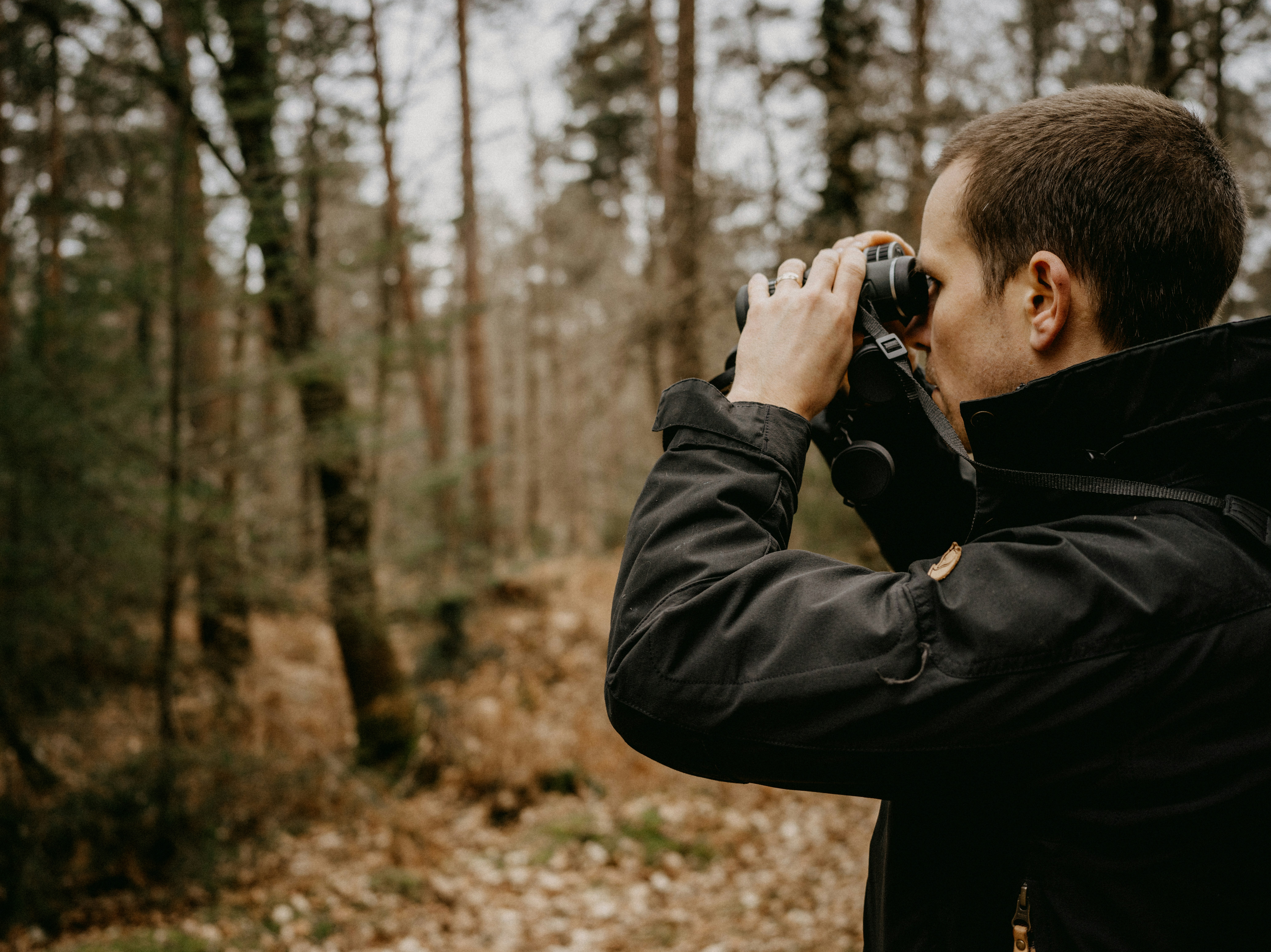 a man taking a picture of a forest with a camera