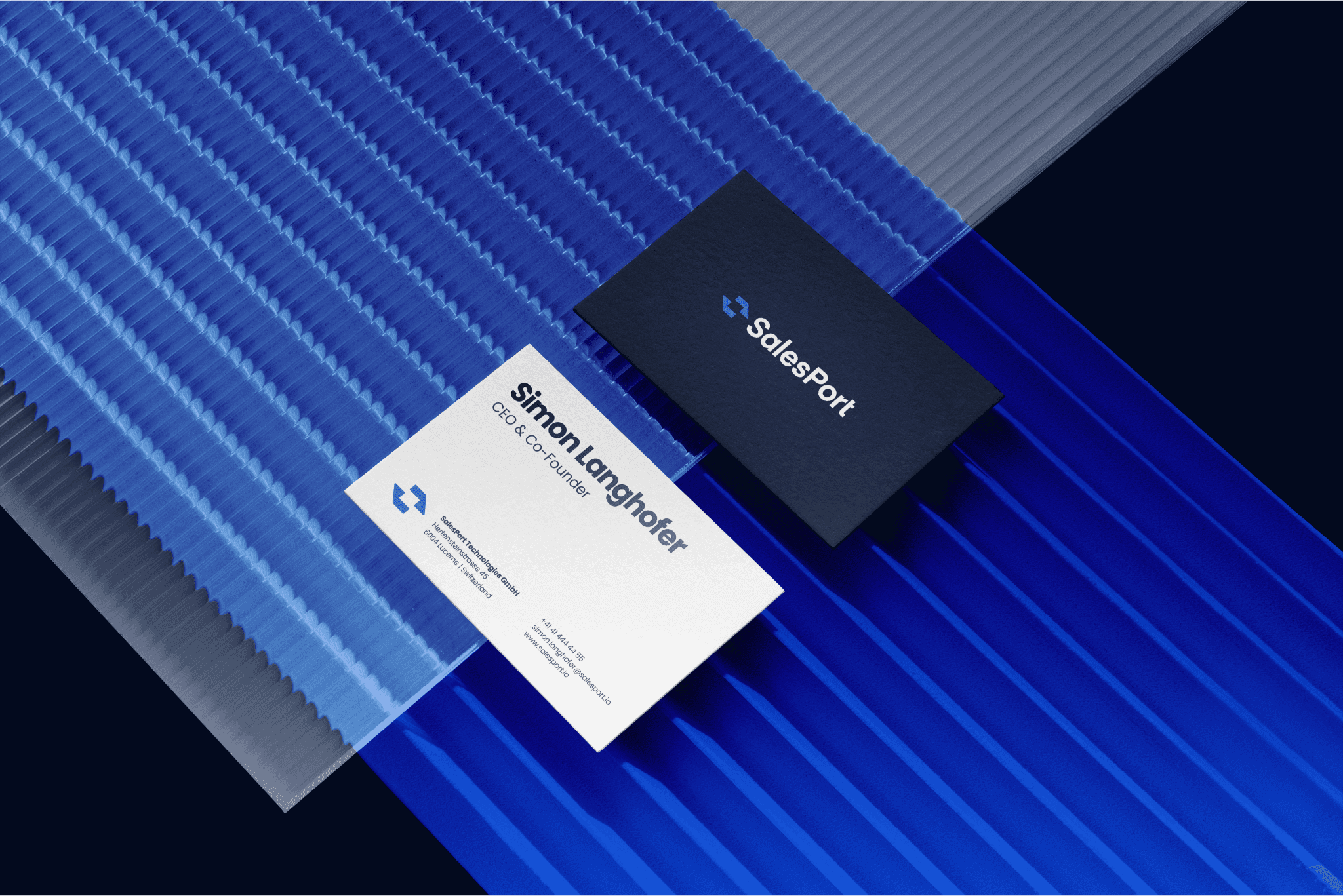 SalesPort business card design showing both front and back, with the brand's blue color matching the background for cohesive identity.