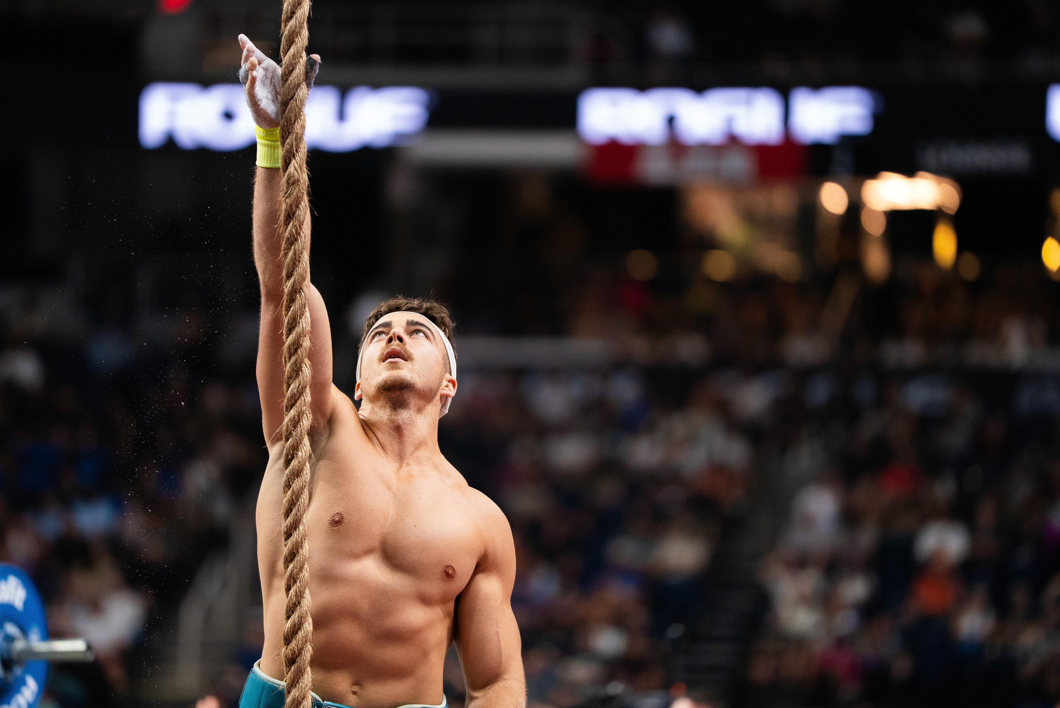 A woman wearing a shiny coat stands in focus, while a blurred background creates a sense of movement.