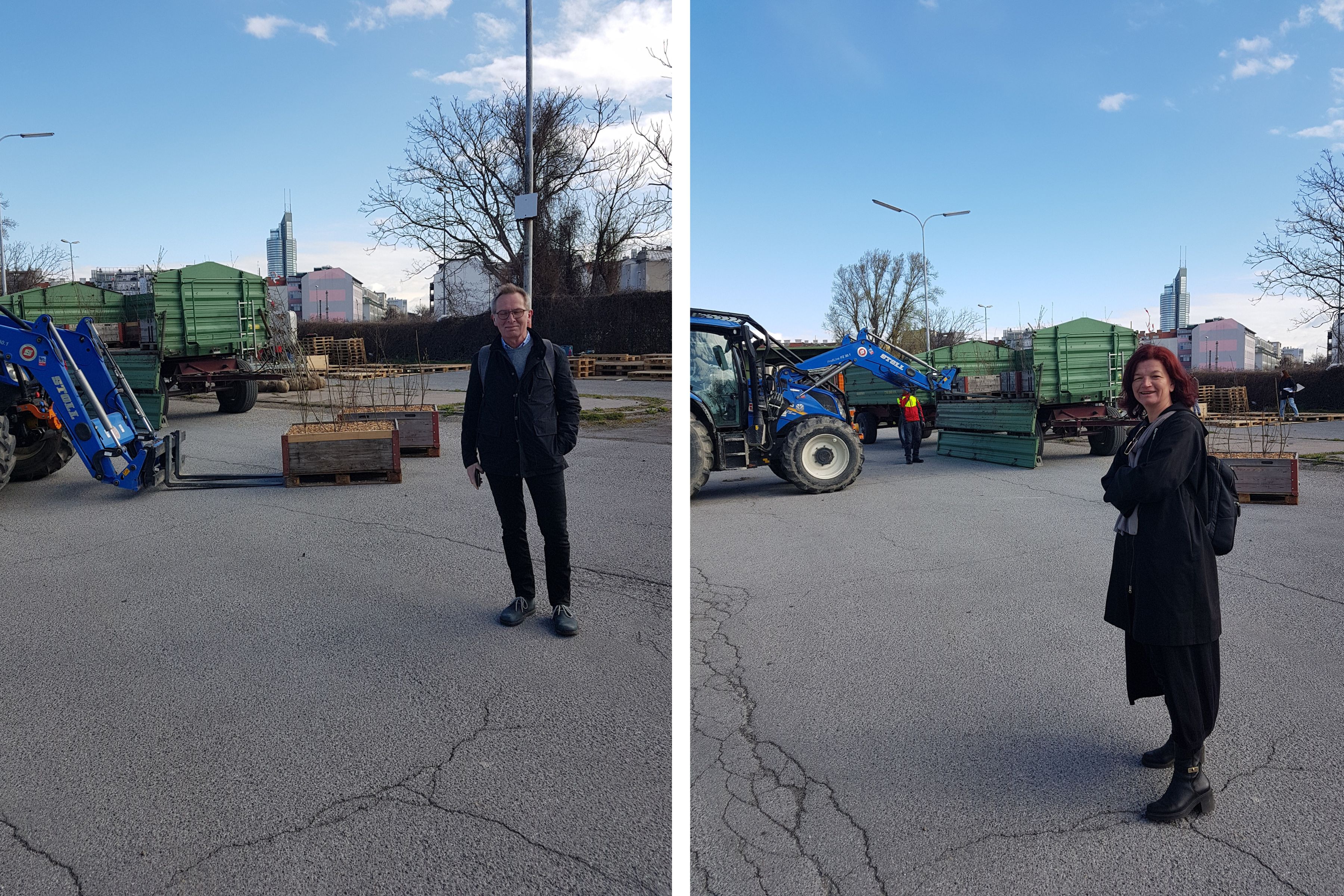 Two side-by-side images of a man and a woman standing in an outdoor staging area with a blue tractor, green trailer, and wooden crates, backed by bare trees and a distant city skyline under a bright sky.