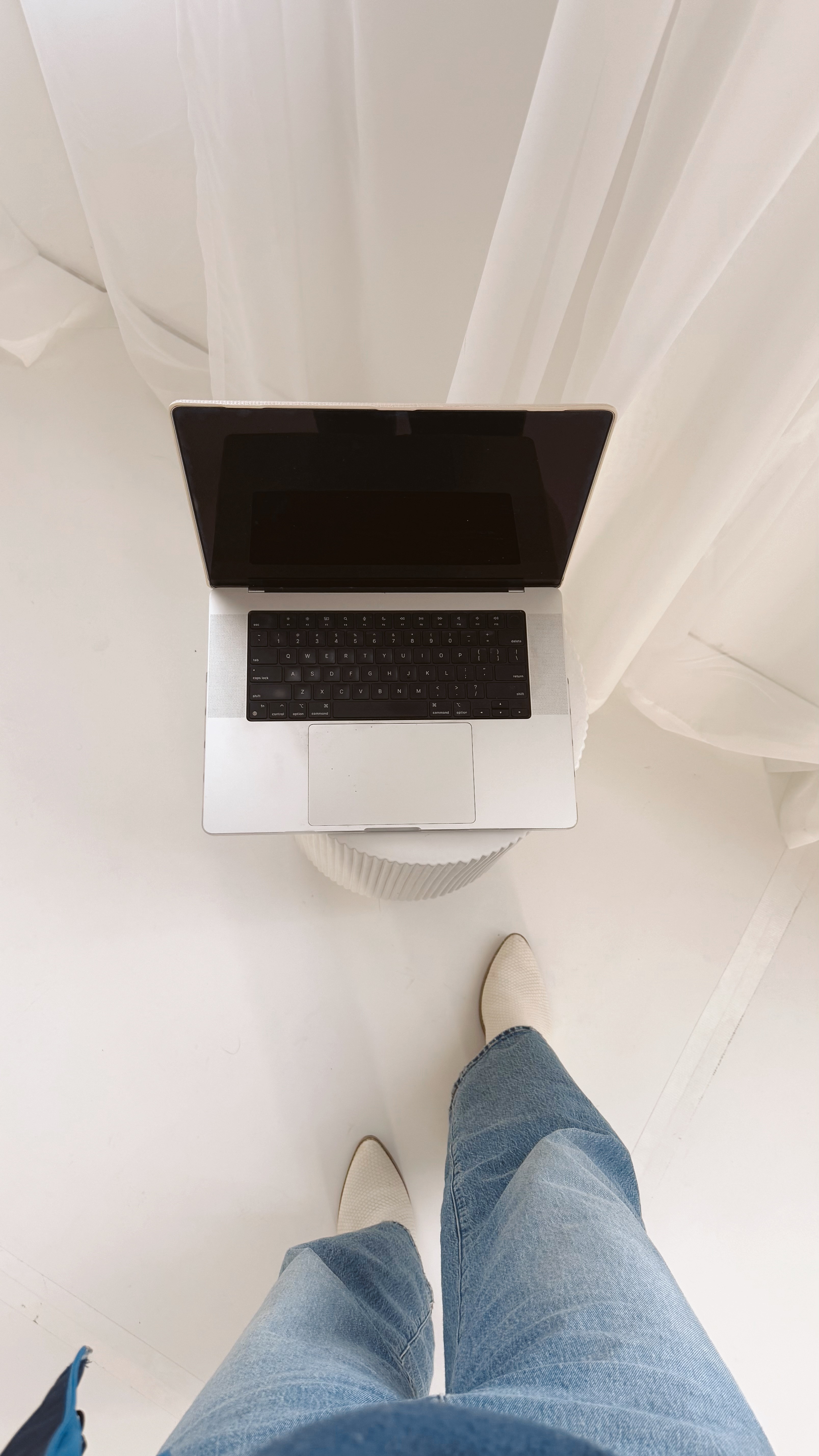 bird's eye view looking down onto a laptop and heels in the frame