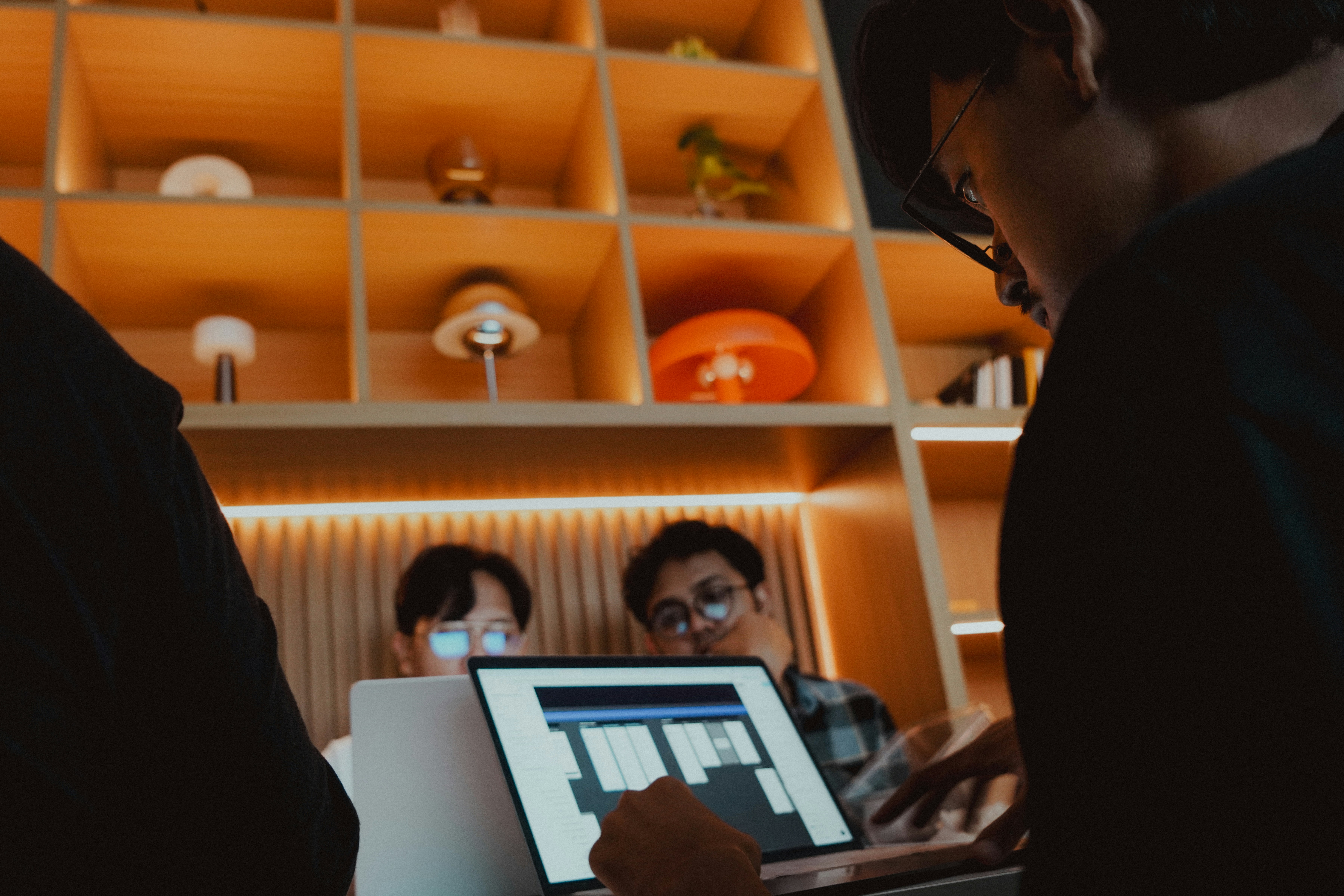 People are working on a laptop in a modern office.