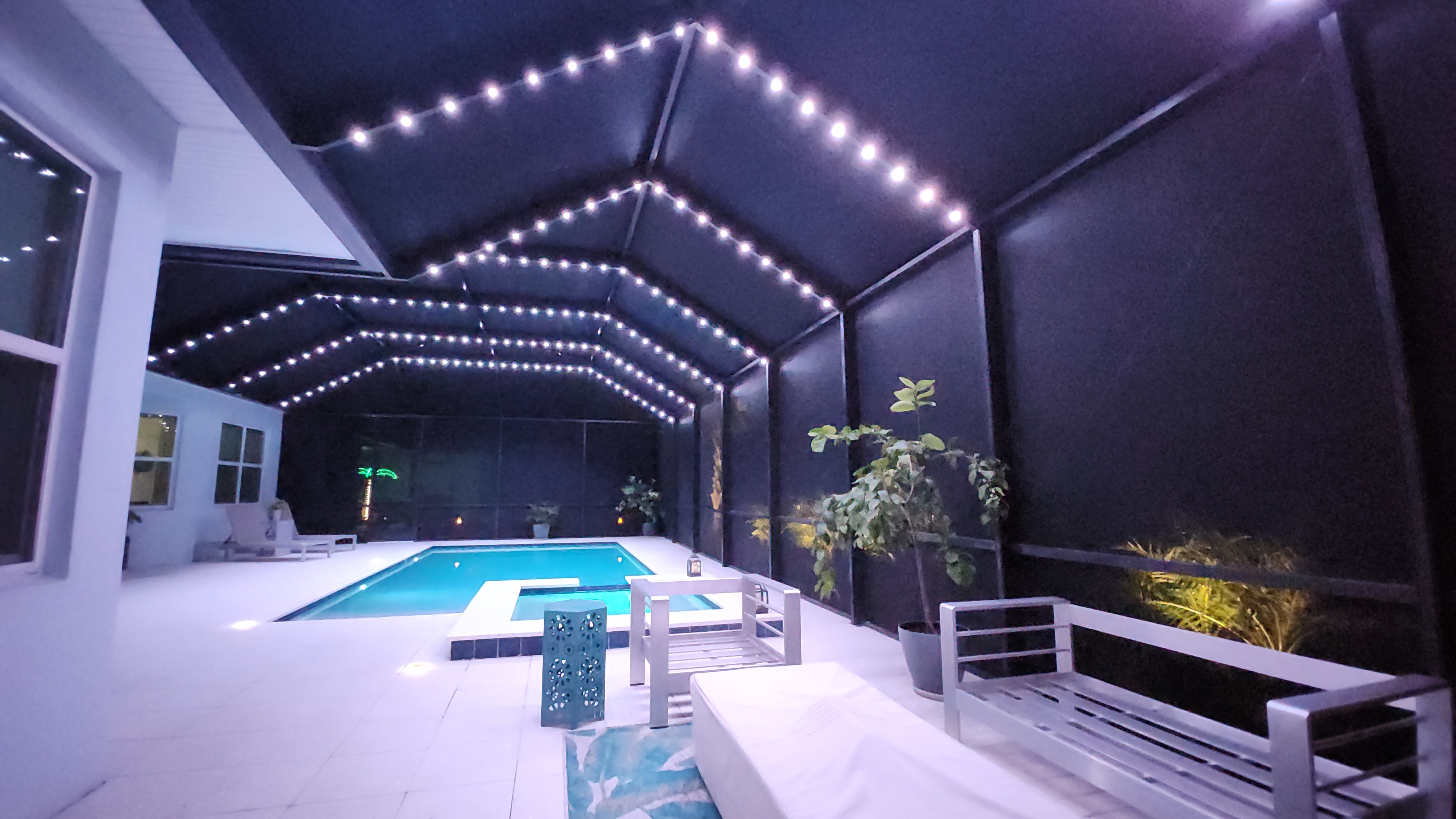 String lighting installed across pool cage ceiling for evening outdoor living