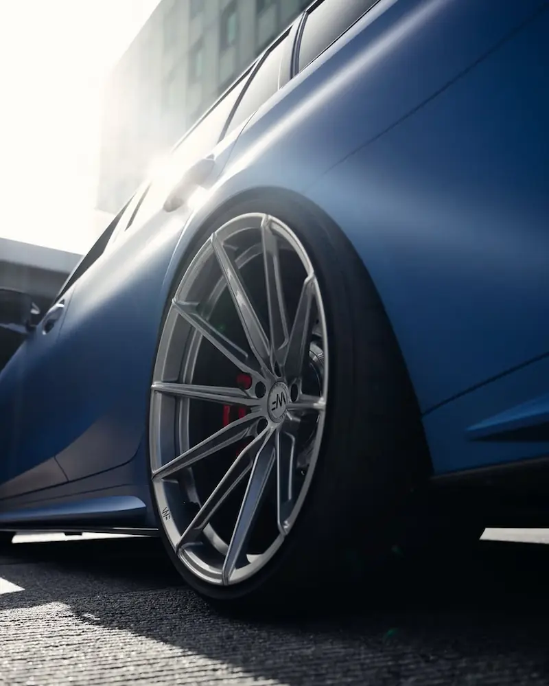 Jante avant d’une BMW M3 bleue mate en contre-plongée