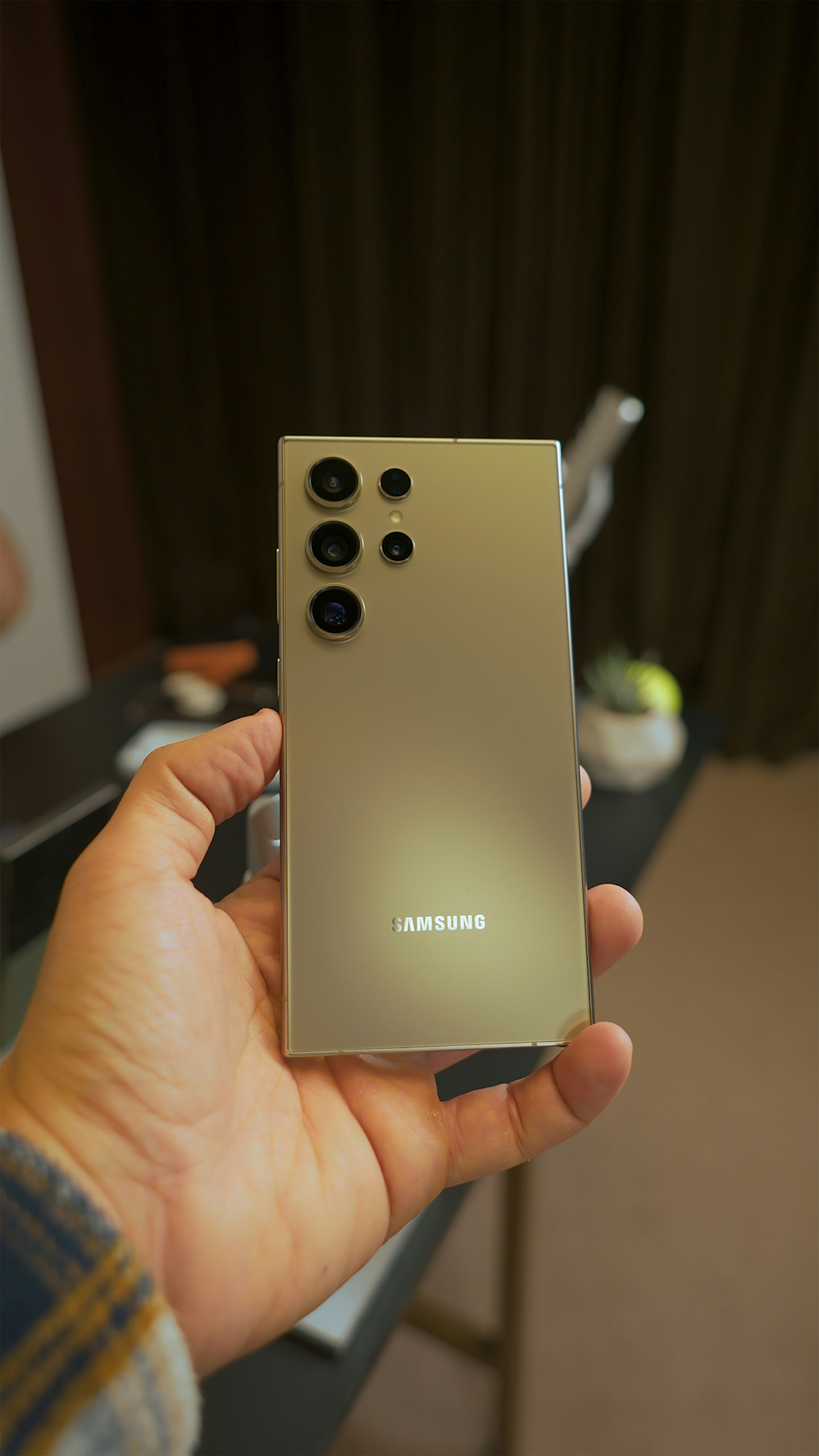 a person holding a silver samsung phone in their hand