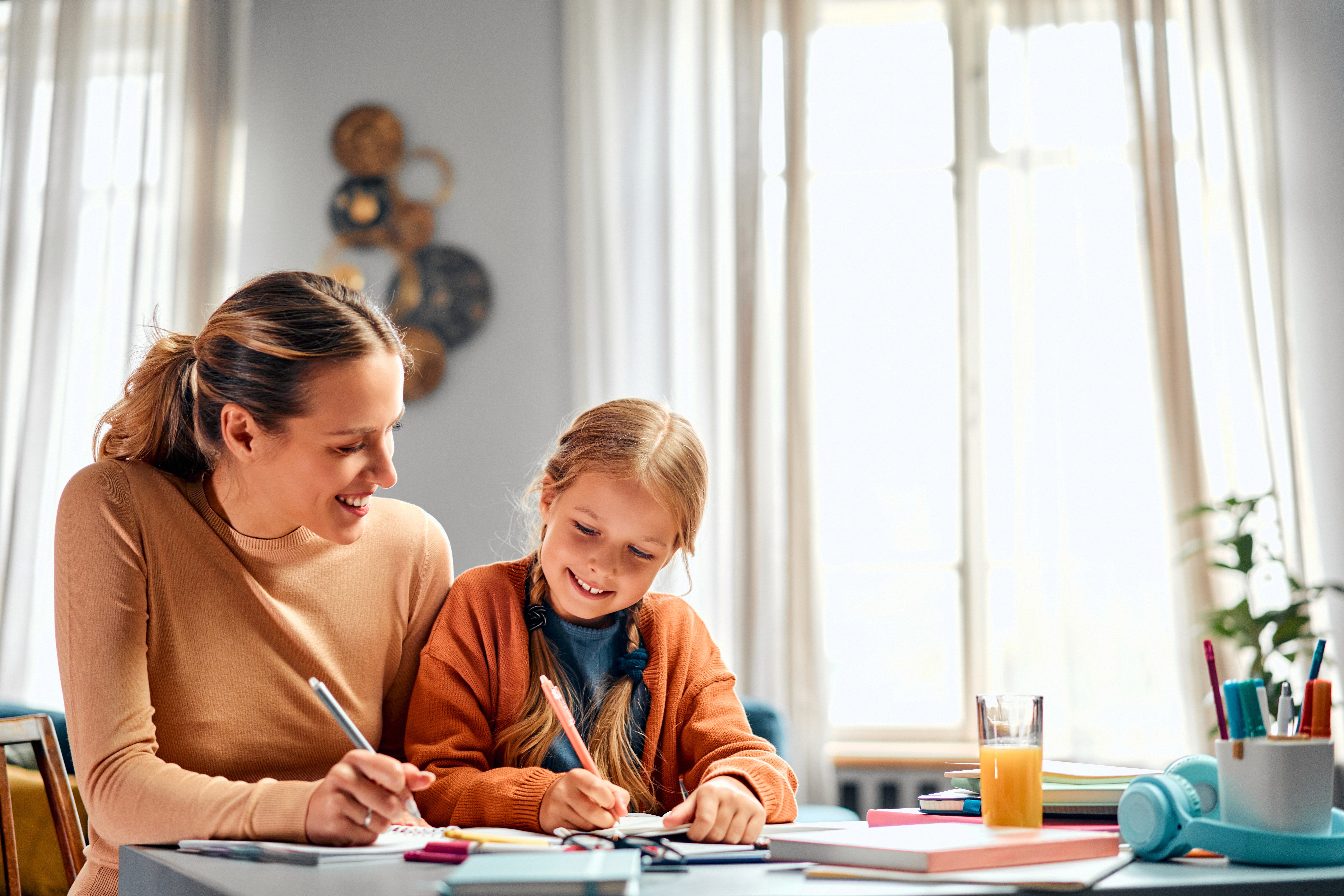 Kind schreibt mit Mama Haushaltsplan