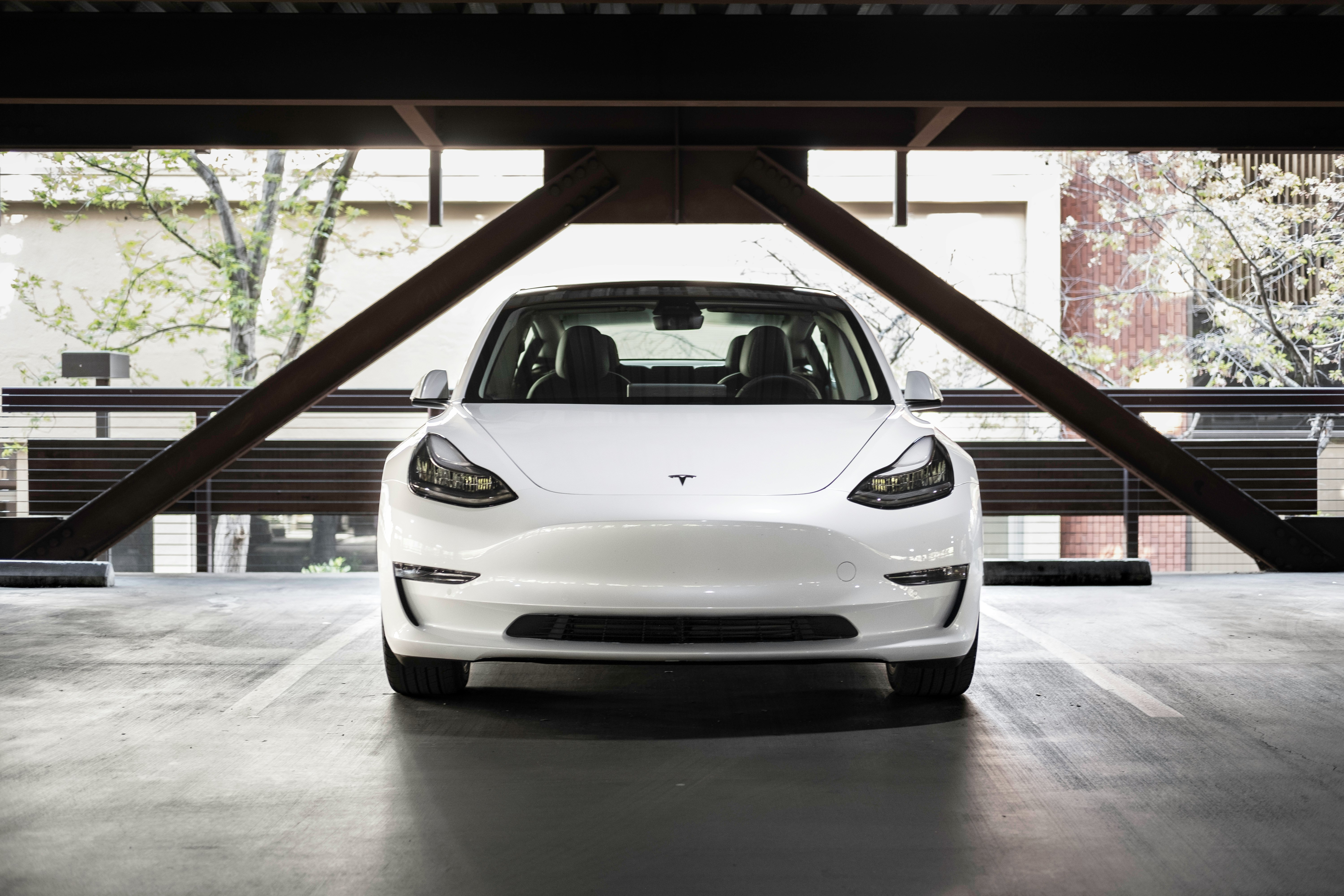 The white 2021 Tesla Model 3 from the front in a parking structure