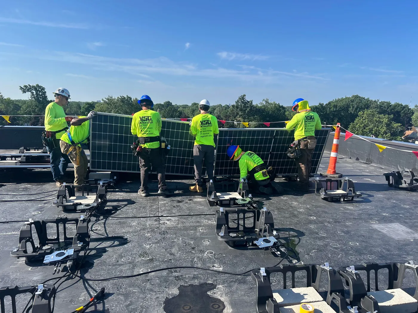 VSG Power crew installing solar panels on a flat commercial rooftop.