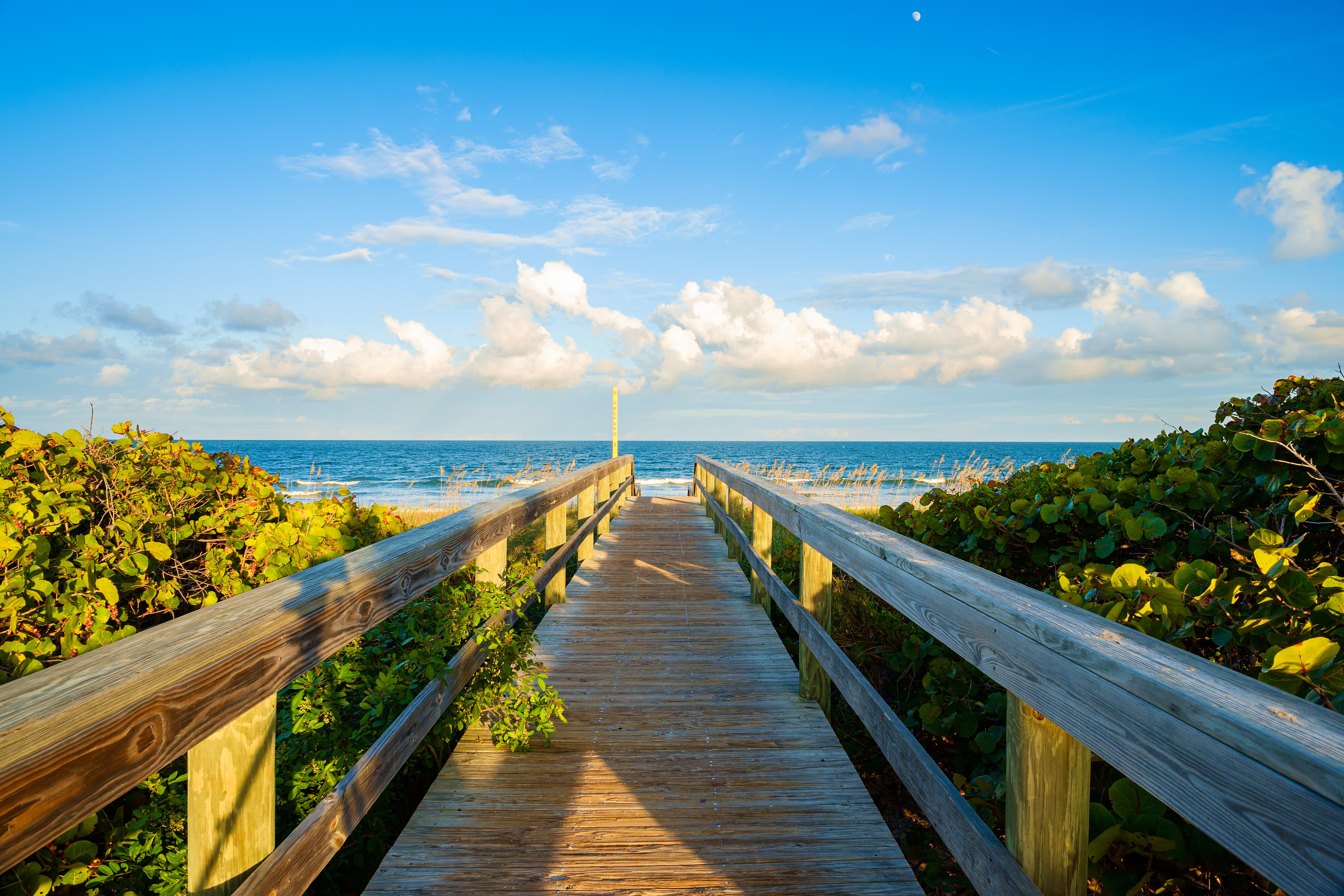  A wooden boardwalk leading toward the Atlantic Ocean at Cocoa Beach, Florida