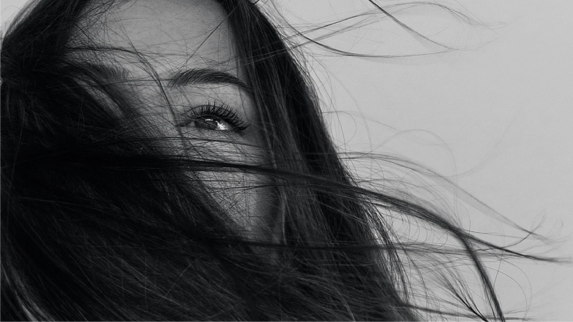 young woman face with hair blowing in wind