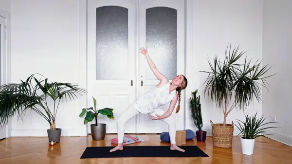 Pregnant woman in a standing side bend yoga pose – prenatal yoga class to release mental expectations around pregnancy through movement and letting go