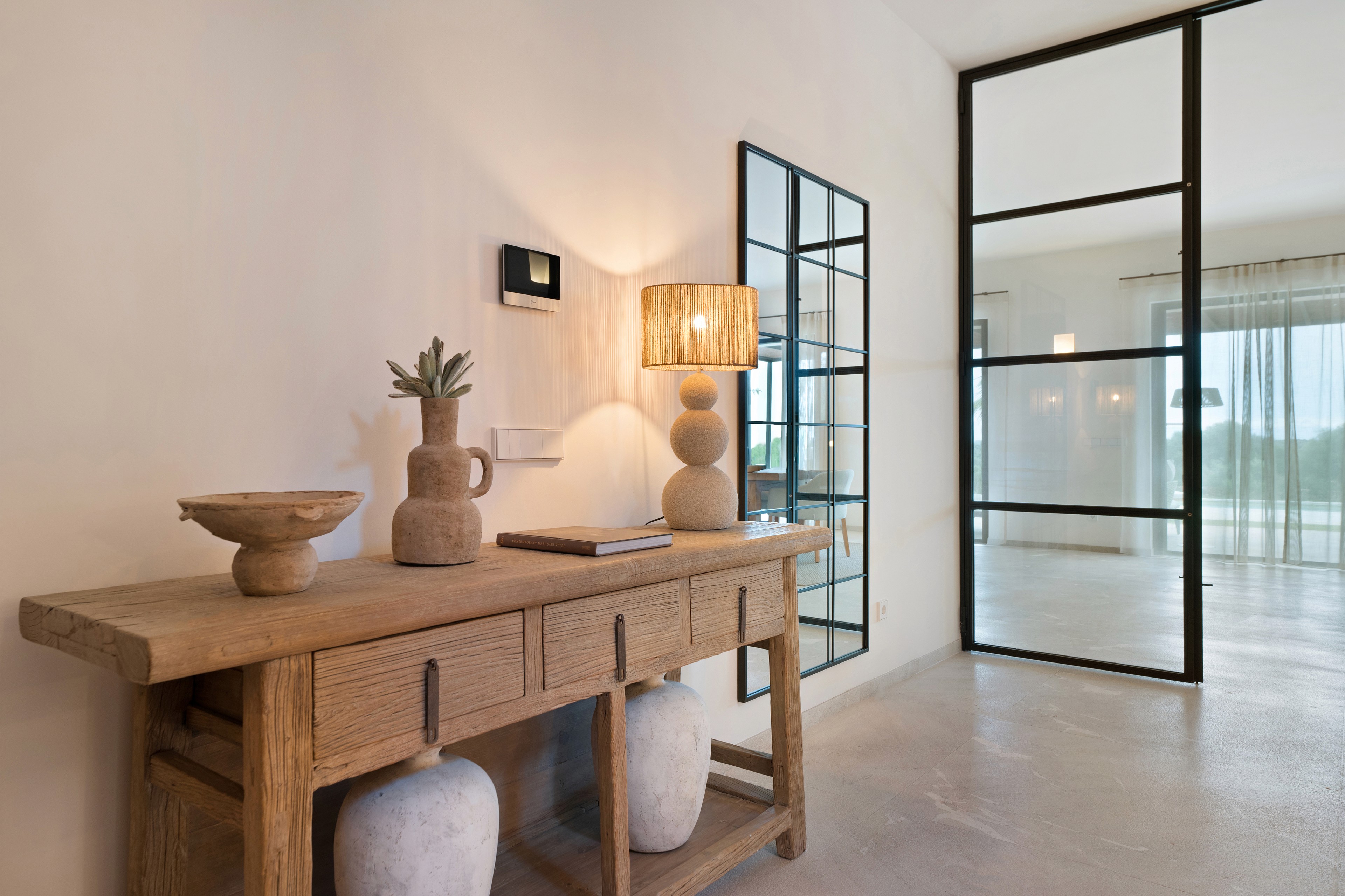 Flur der Finca in Ses Salines gestaltet von Home Styling Mallorca mit Holzkonsole, Naturmaterialien und klarer Architektur