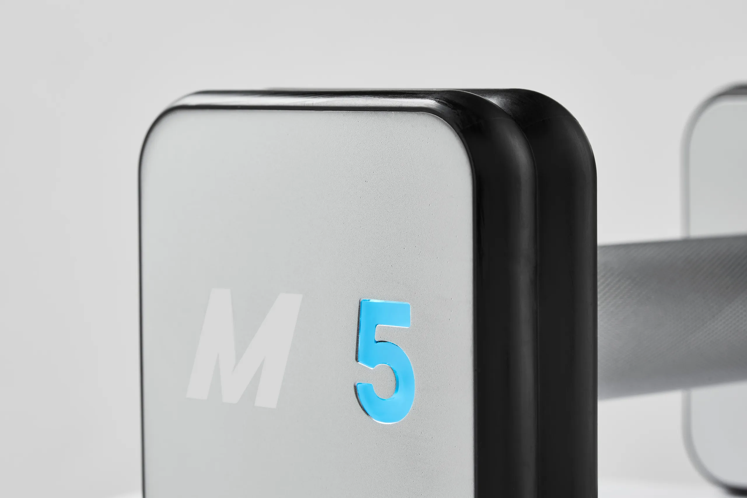 Close-up of a Mirror smart dumbbell end displaying the M5 weight indicator