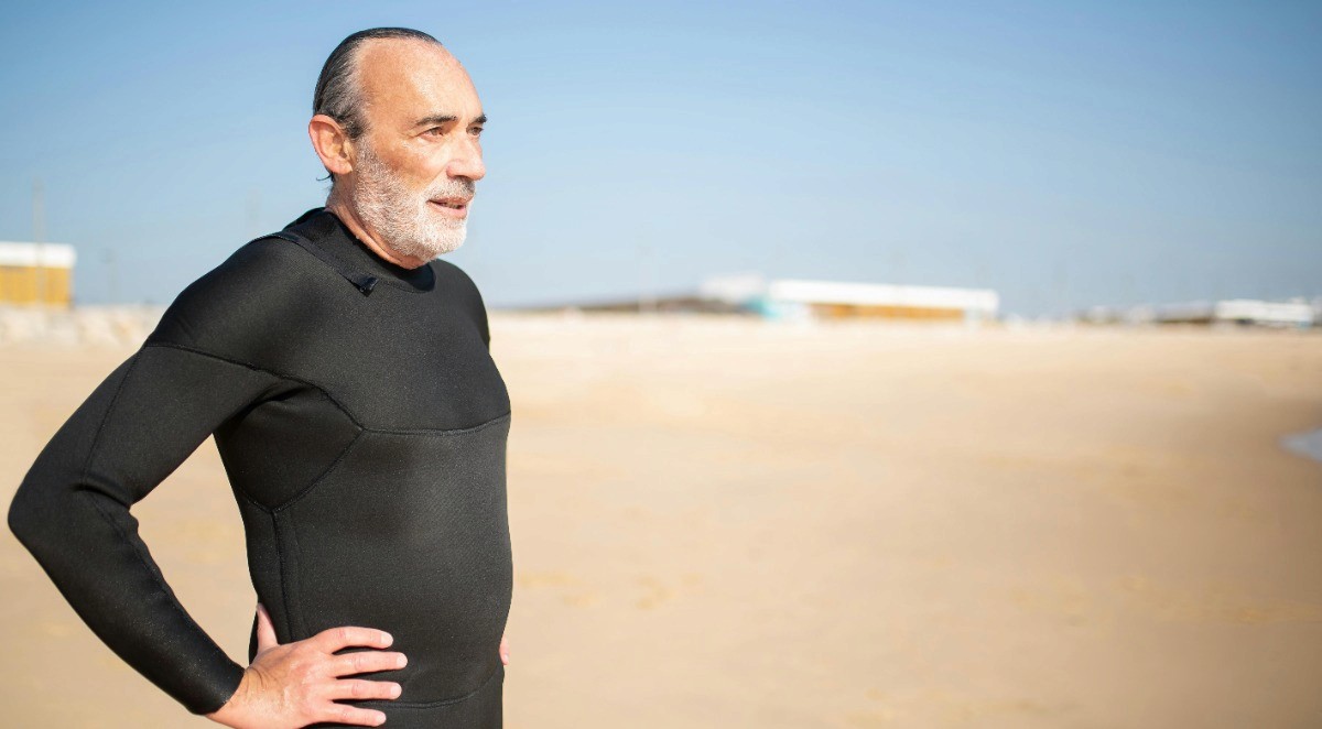Hombre mayor en la playa contemplando el horizonte