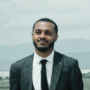 Modern bathroom featuring a walk-in shower, wooden vanity, round mirror, and elegant marble tiles.