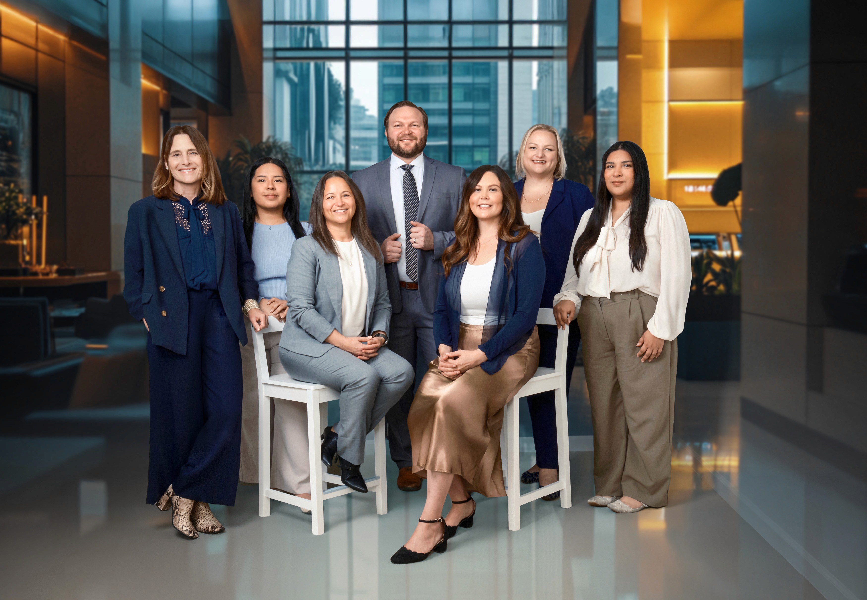 Team branding photo of diverse women business leaders posed in modern office