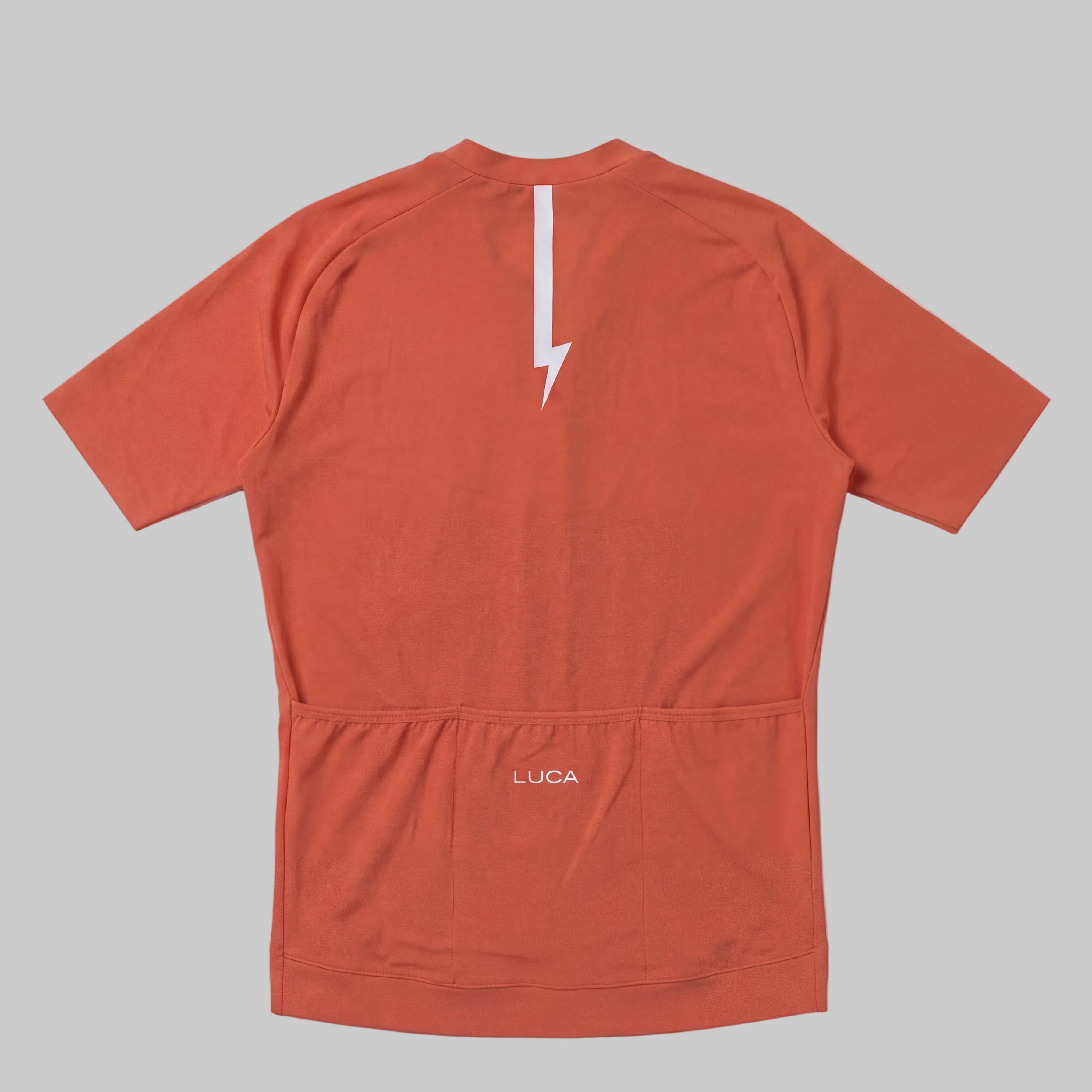 LUCA Soleil women's cycling jersey in aperol - back view with reflective bolt and pocket detail