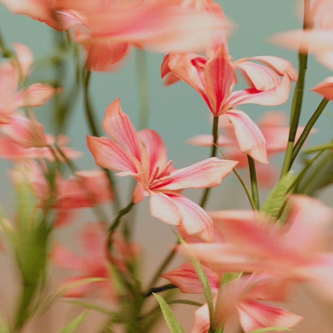 A young person with brown hair, wearing reflective silver sports sunglasses and a black sweater, looks at the camera while resting their chin on their hand.