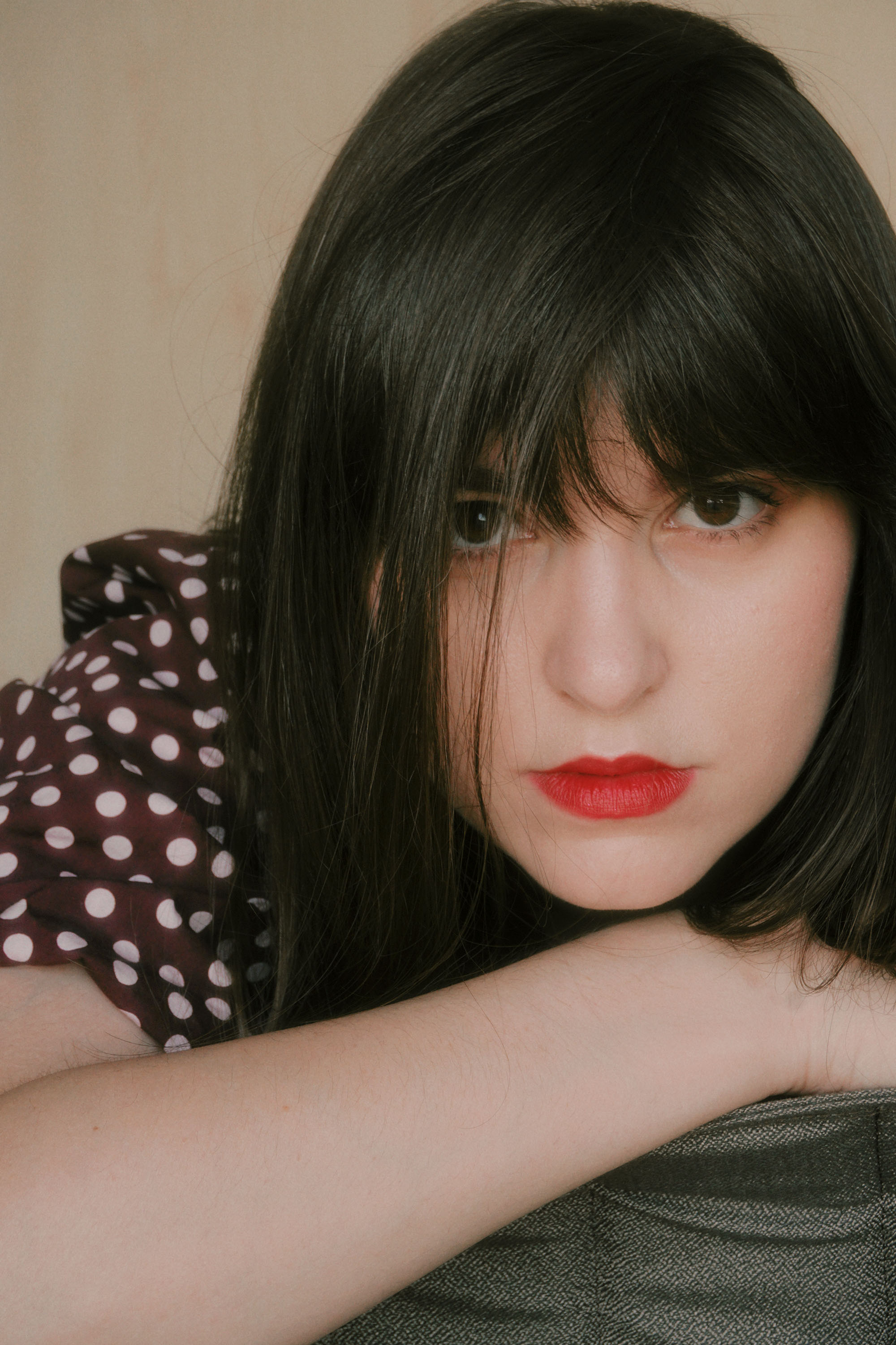 Portrait of Aida wearing polka dot blouse with red lipstick