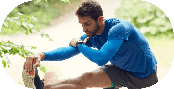 A man stretching his hamstrings after his workout routine