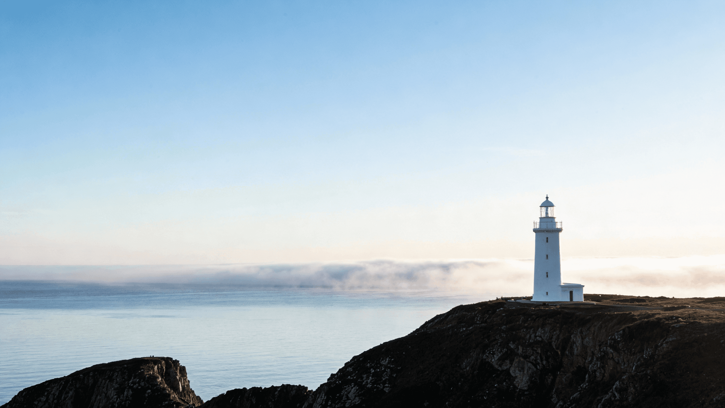 woman in blue tank top standing beside white wall